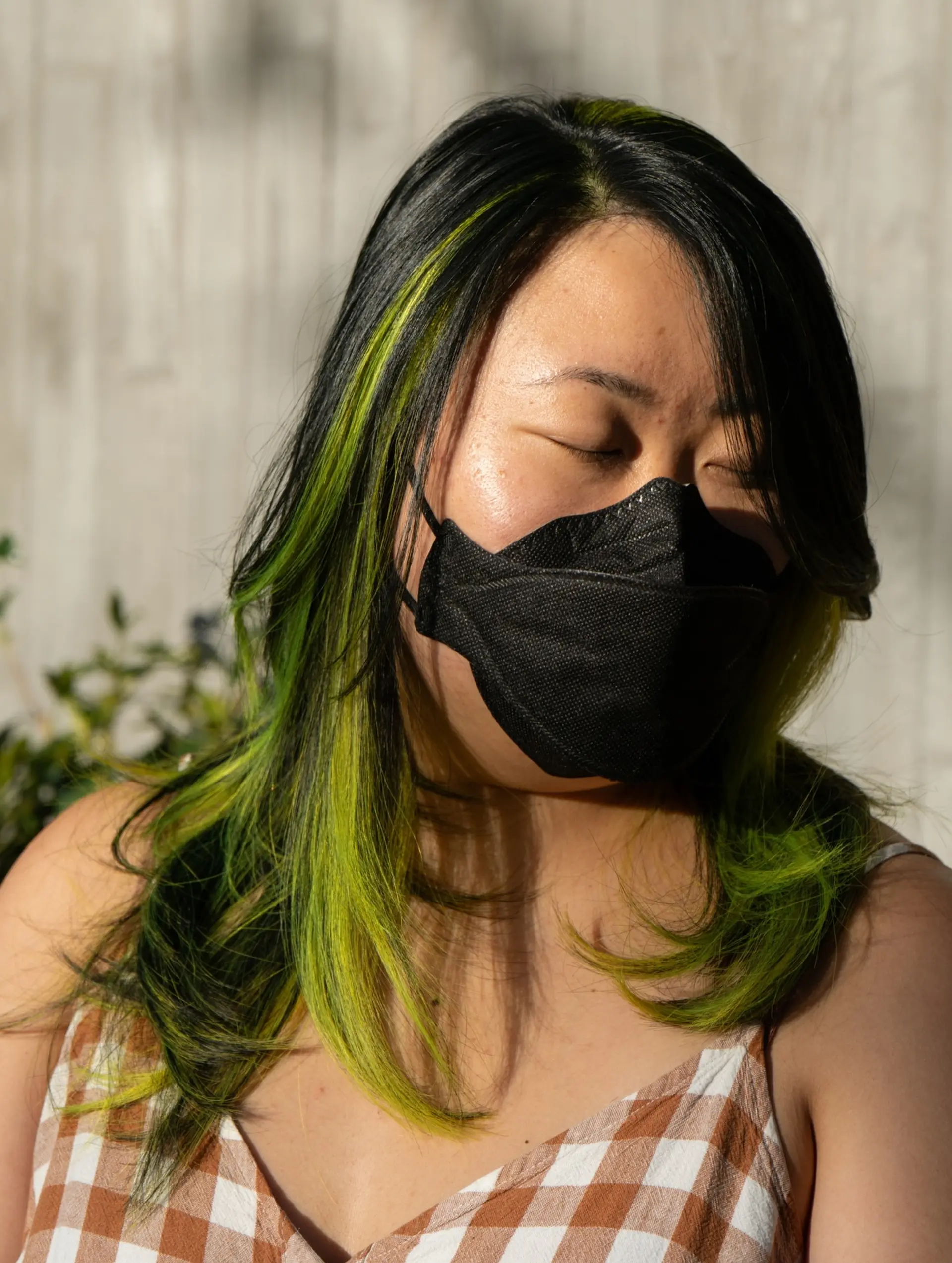 Medium-length black hair with vibrant lime green peekaboo color blocking and face-framing layers. 1