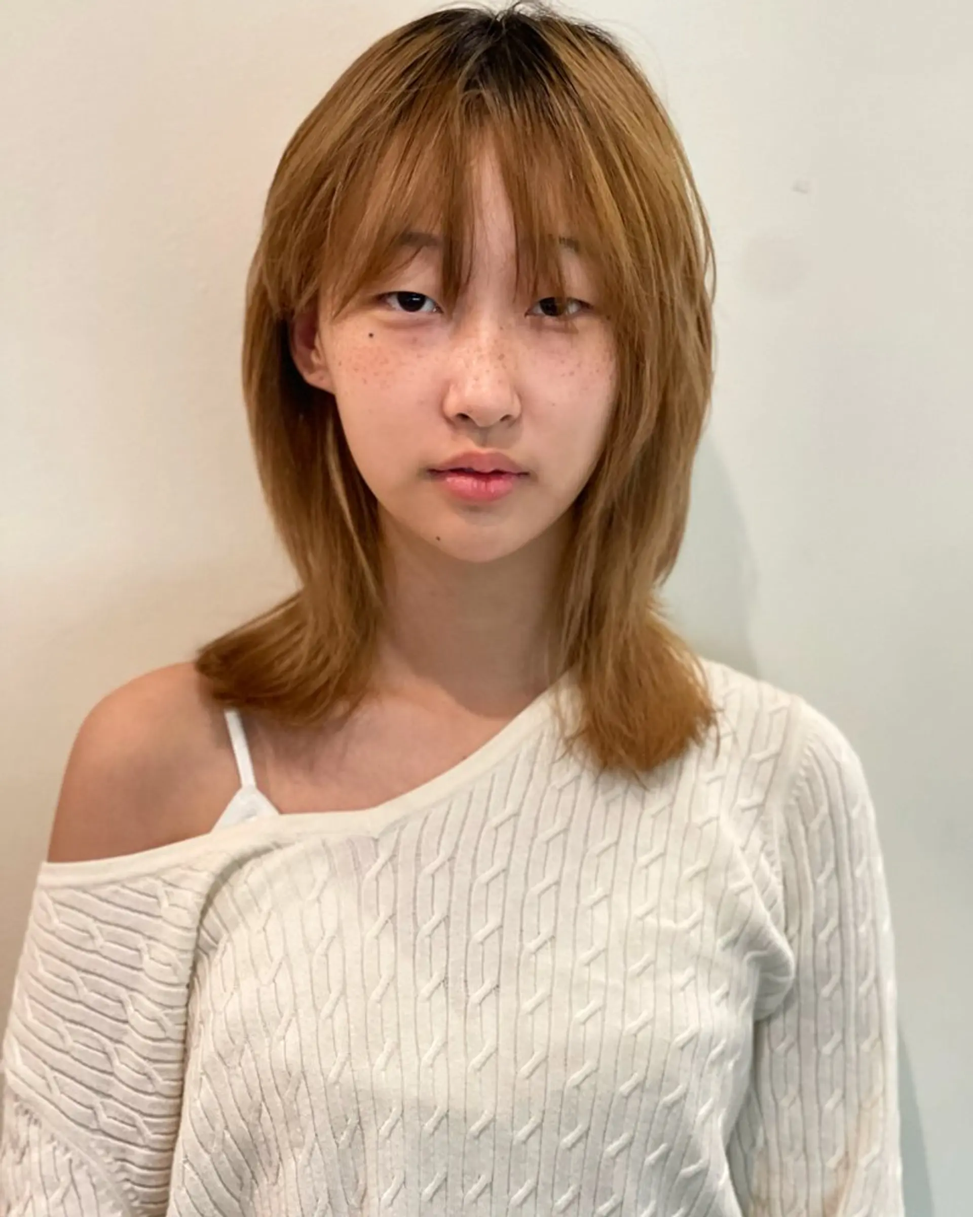 A trendy shag haircut with face-framing layers and curtain bangs. 1