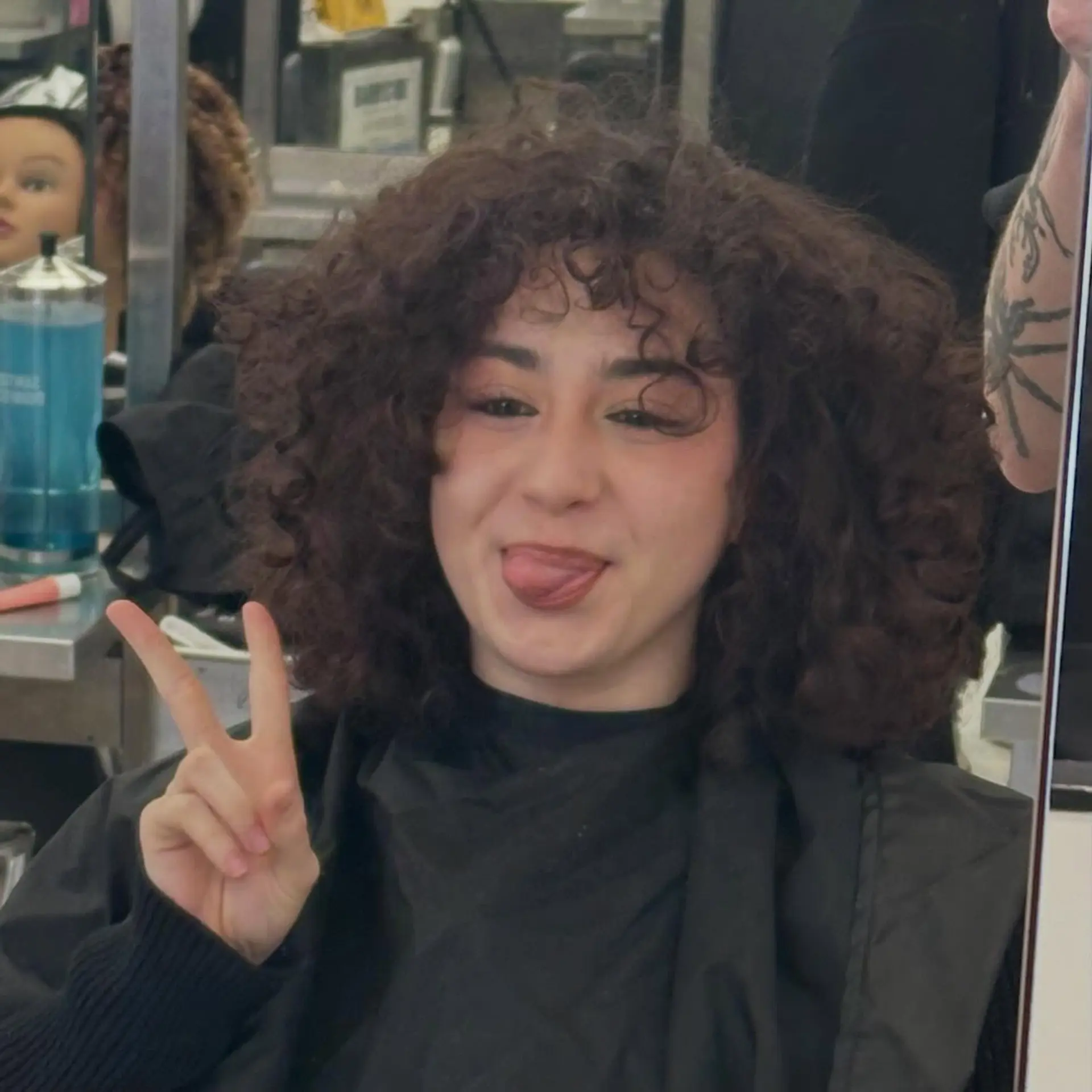 A rounded, voluminous curly haircut falling around shoulder length with defined curls and matching curly fringe. 1