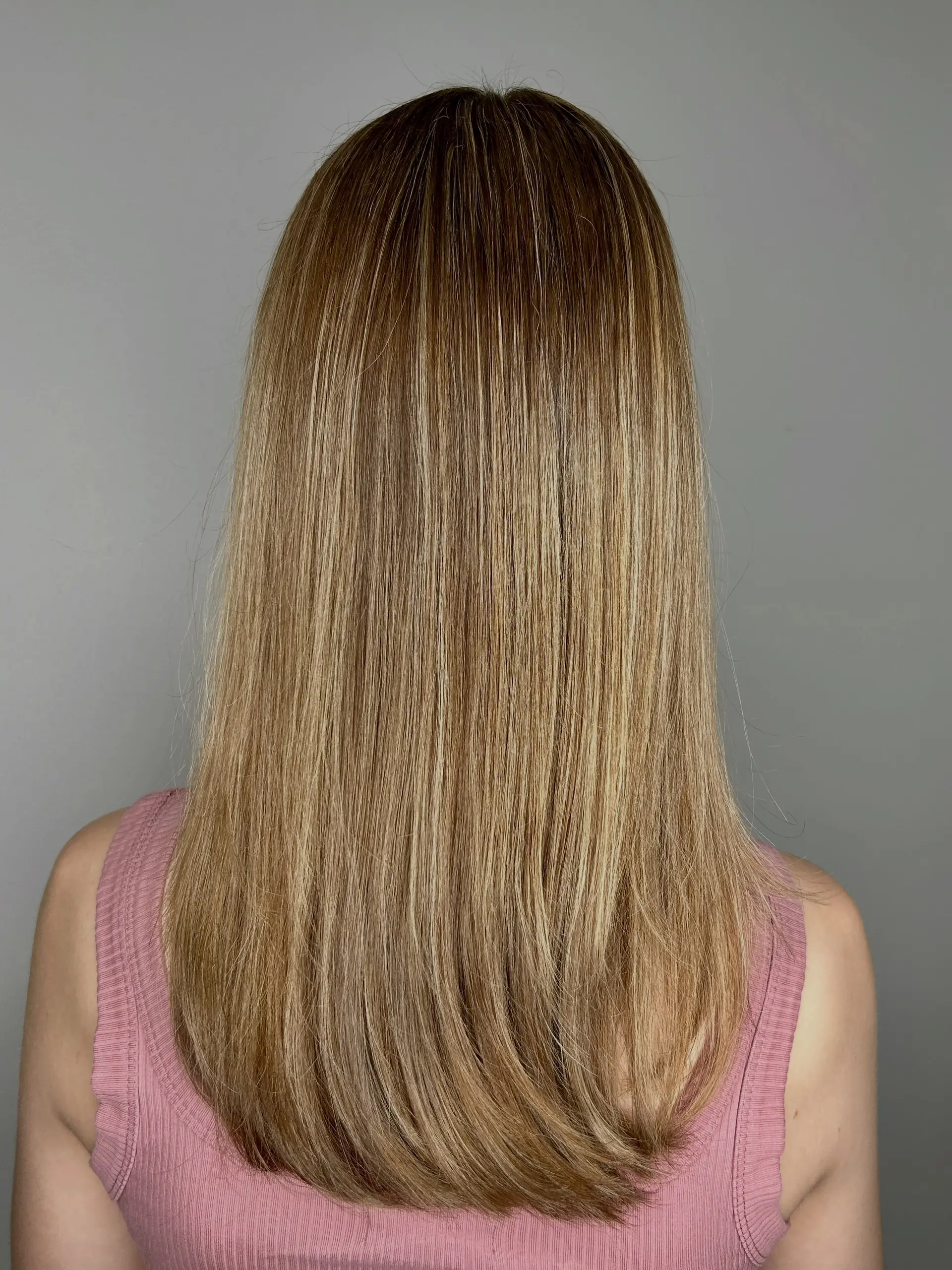 Long, smooth straight hair featuring finely blended warm blonde highlights over a light brown base. 1