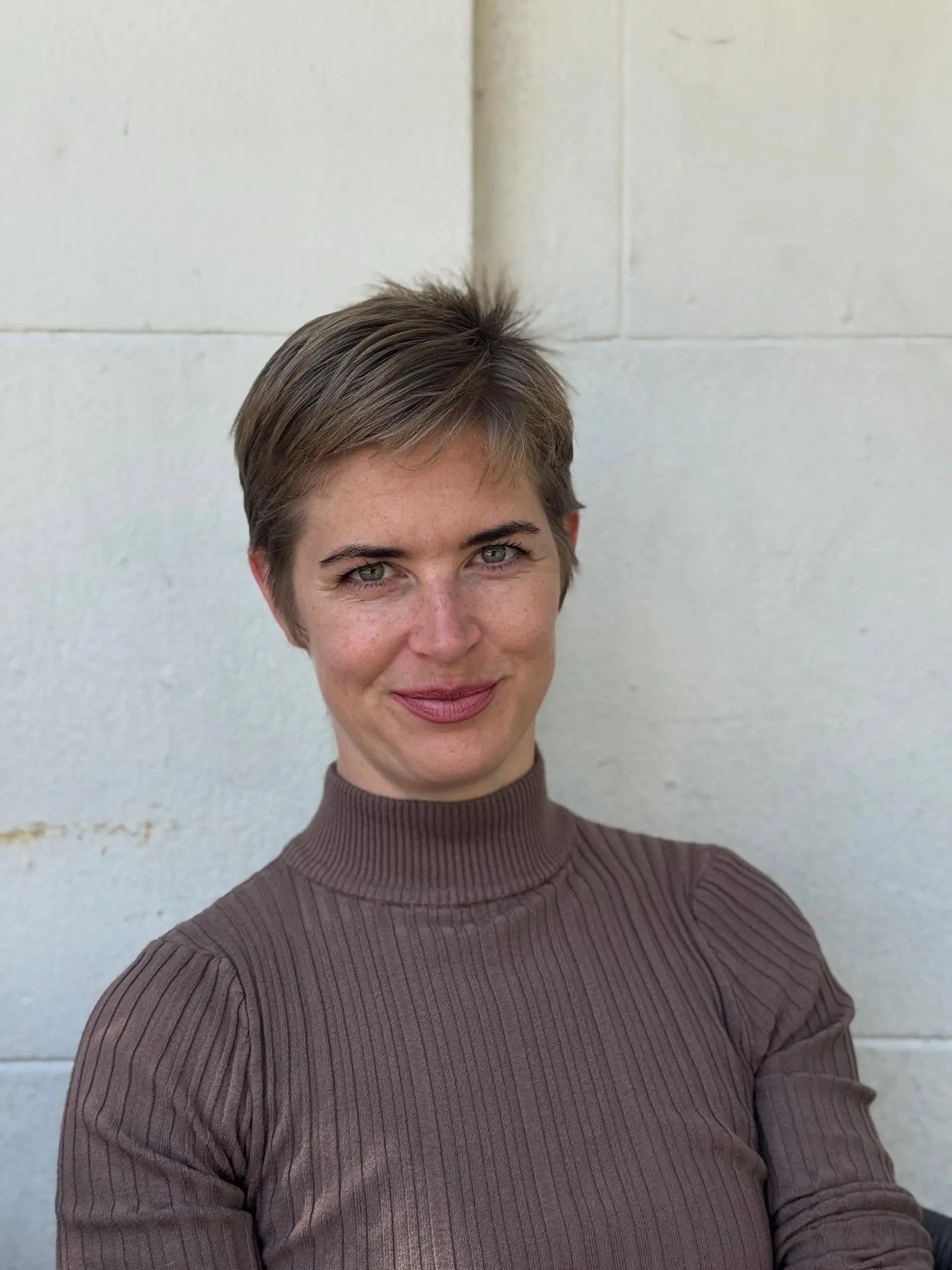 A short, textured pixie cut with side-swept fringe and subtle layering. 1