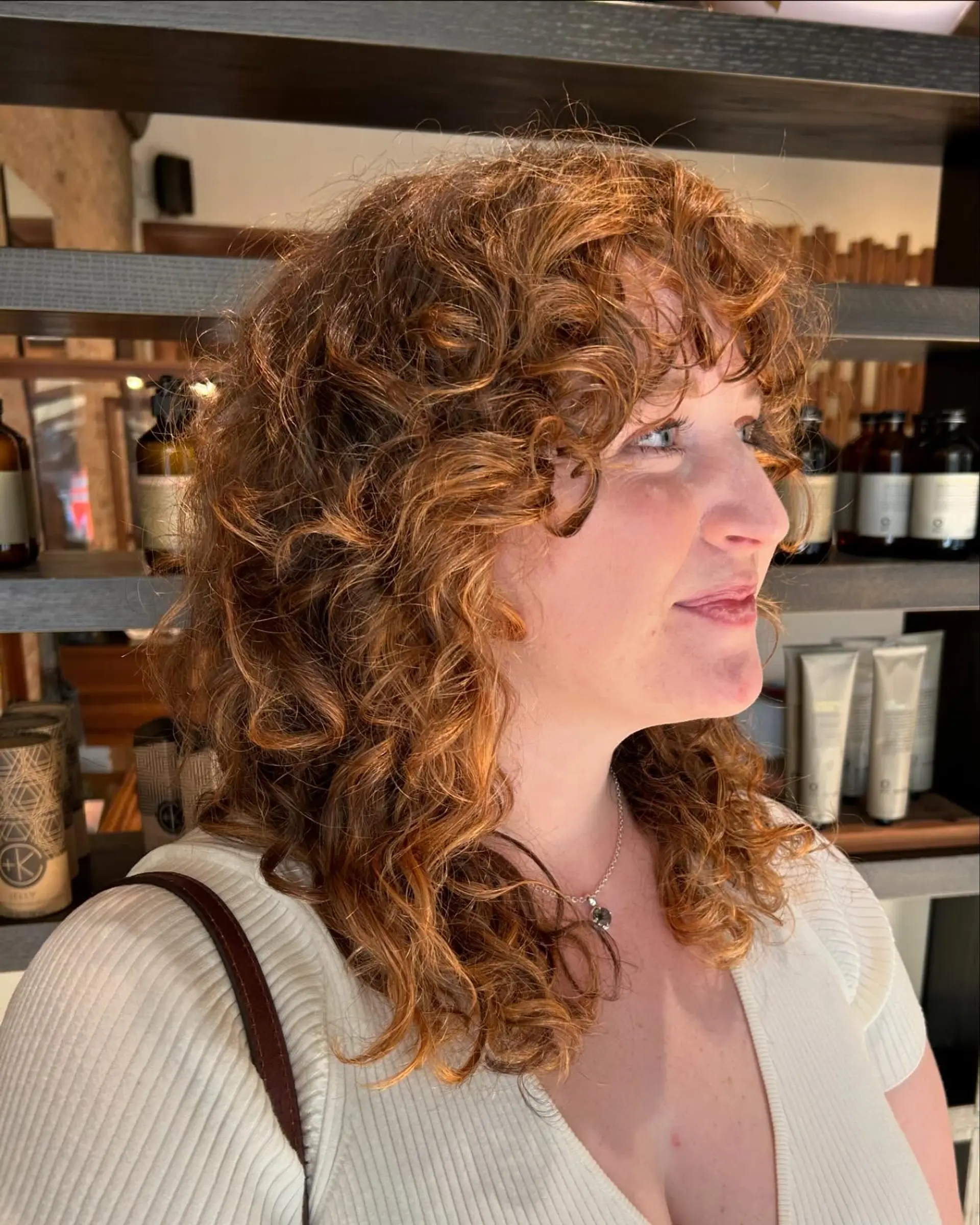 A trendy medium-length curly shag with face-framing bangs. 2
