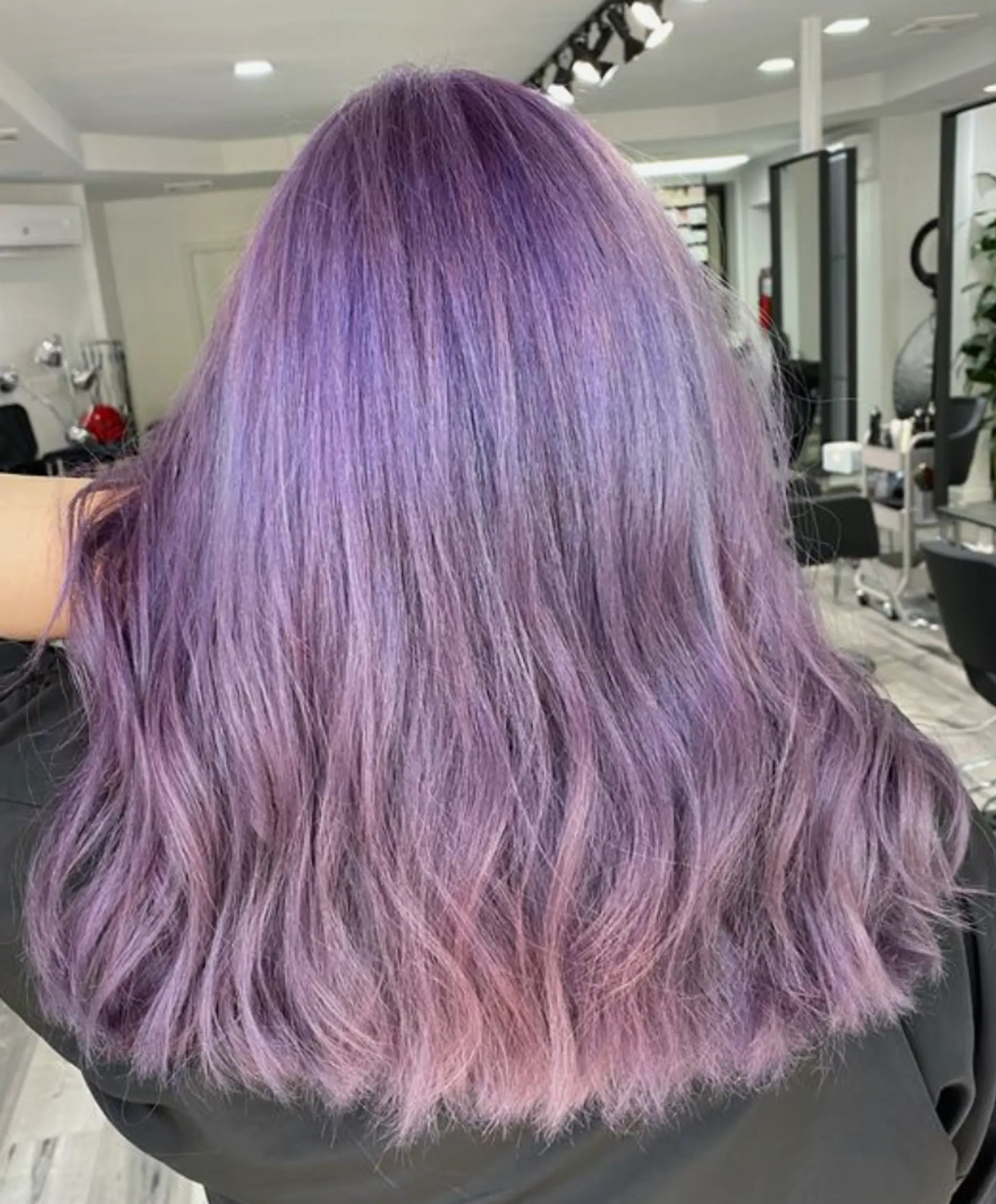 Long, wavy tresses with a gradient from lavender to purple, creating a romantic and soft look.