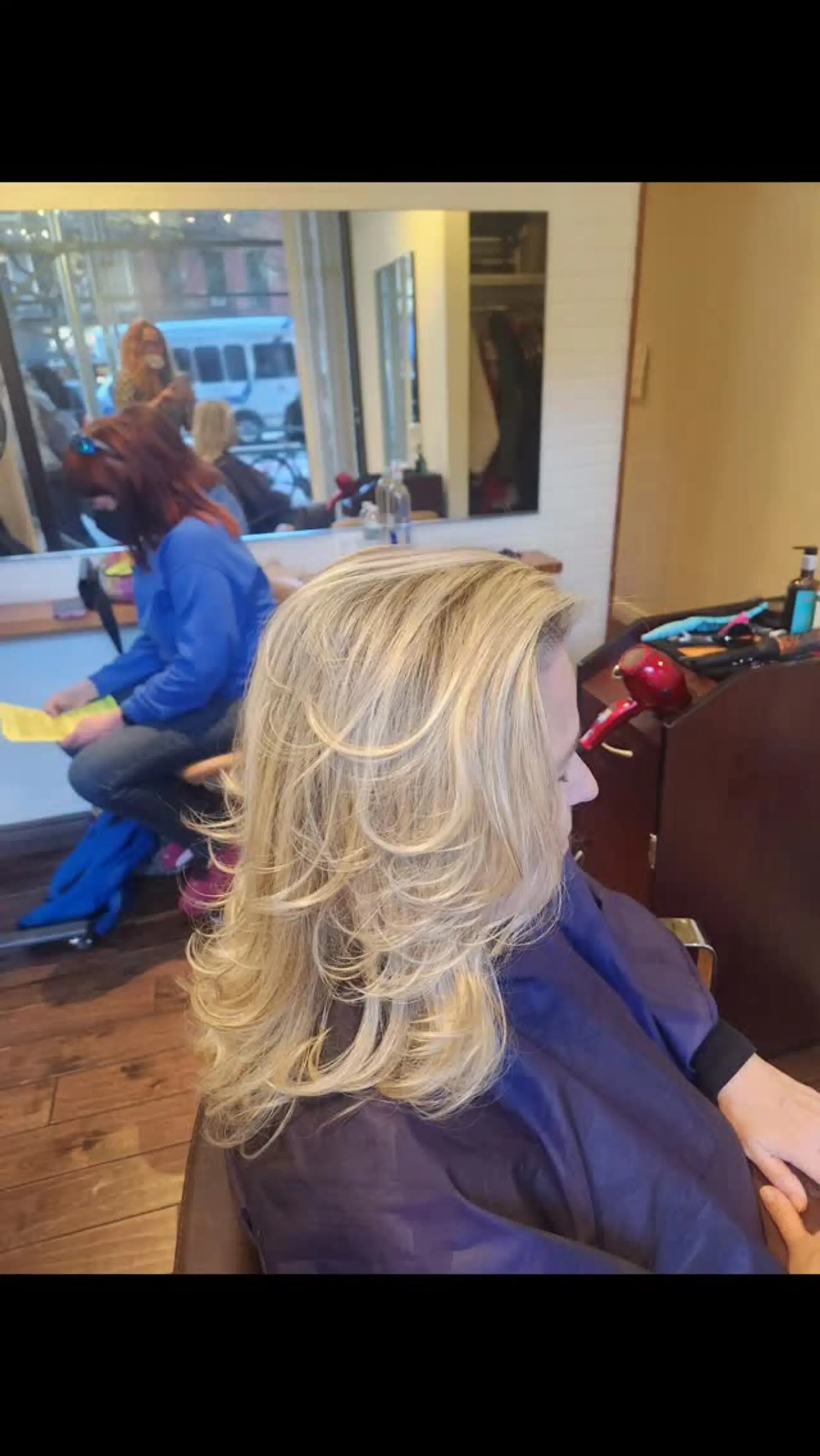 A medium-length golden blonde hairstyle featuring textured, feathered layers styled with voluminous flipped ends. 1