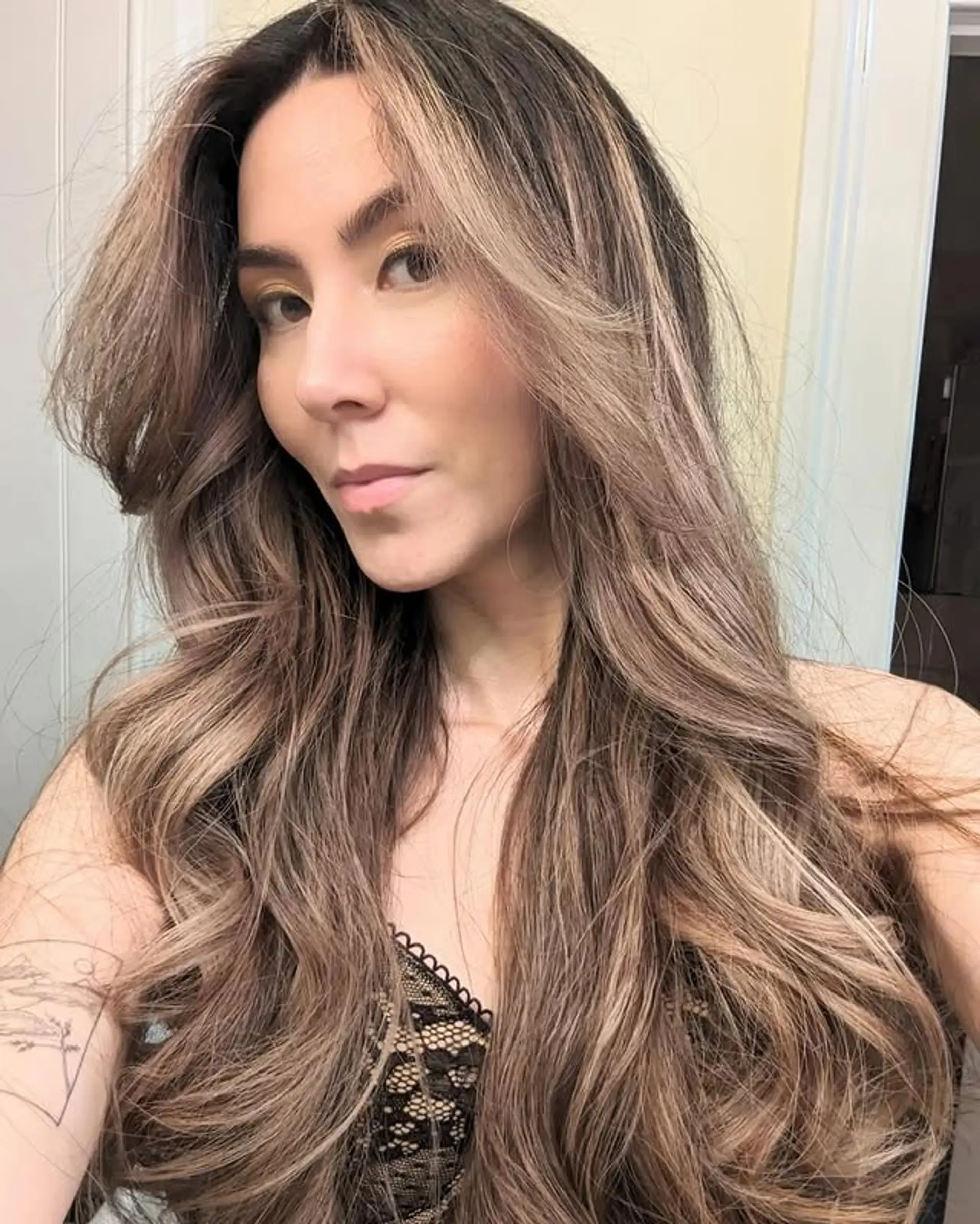 A long and wavy bronde hairstyle with face-framing layers for a trendy, dimensional look. 1