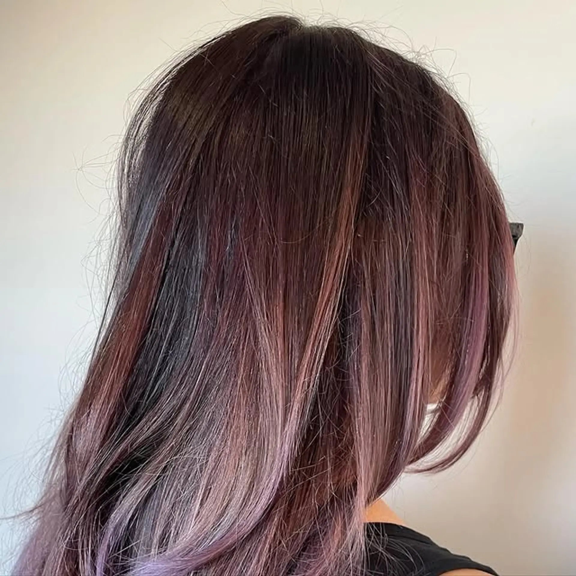 A trendy ombre style with dark roots blending into a light purple shade. 1