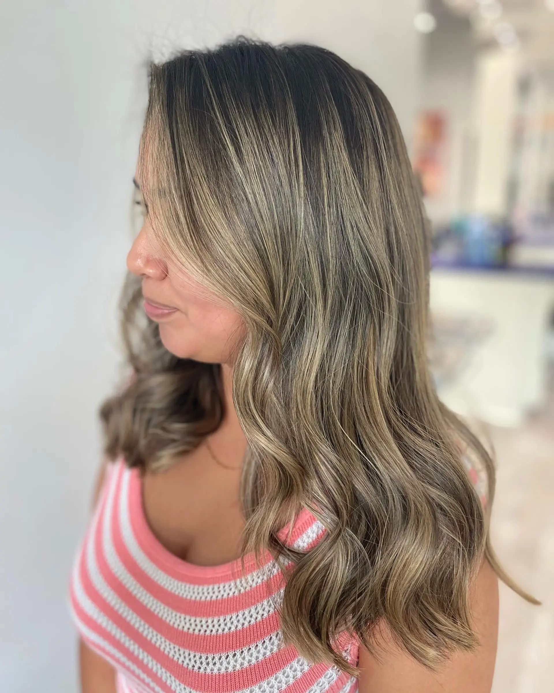 Long wavy hair with caramel ribbon balayage highlights for a trendy, dimensional look. 2