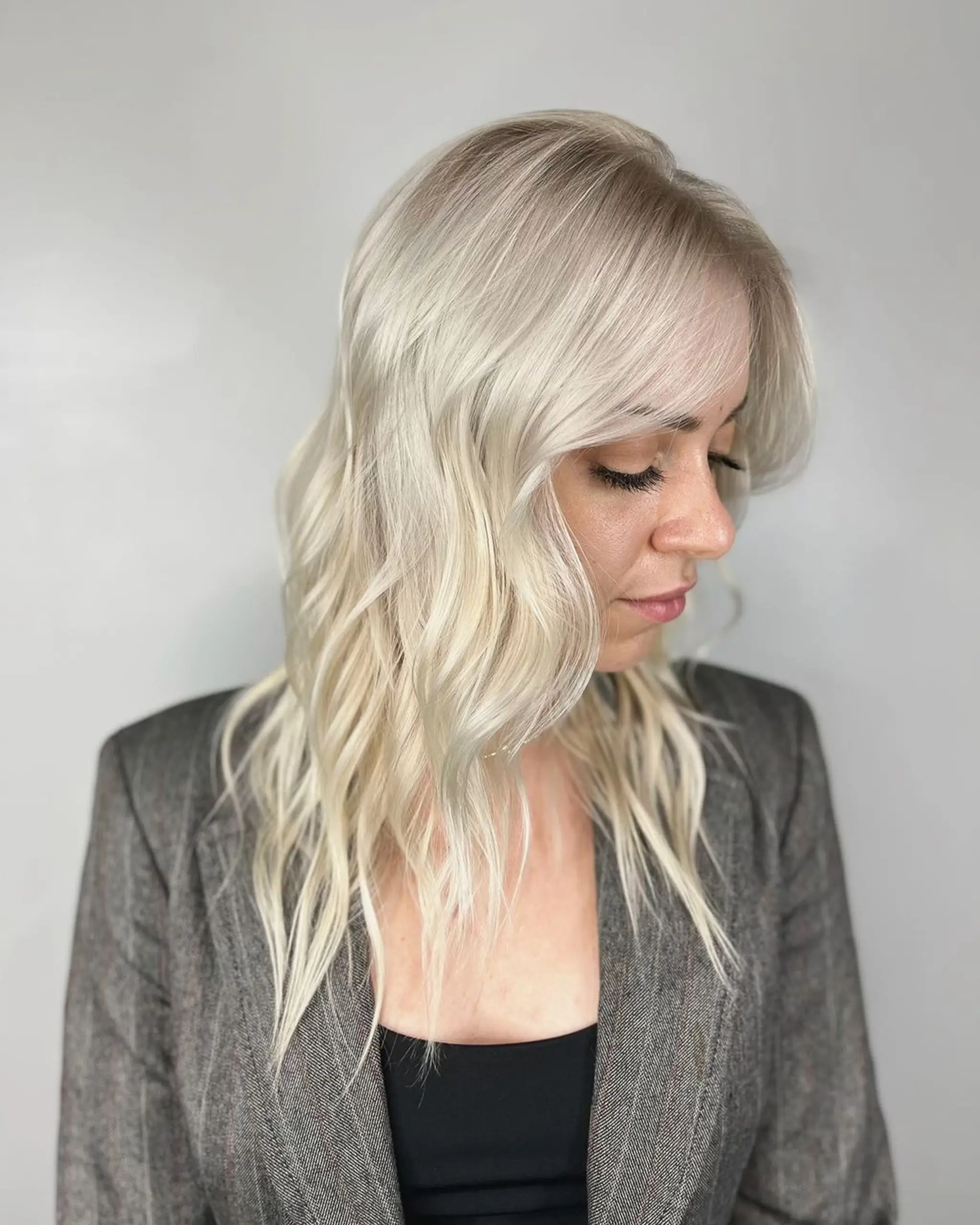 Medium-length platinum blonde hair with soft, natural waves and a side part. Light fringe frames the forehead.
Stylist - @xcellent_jason