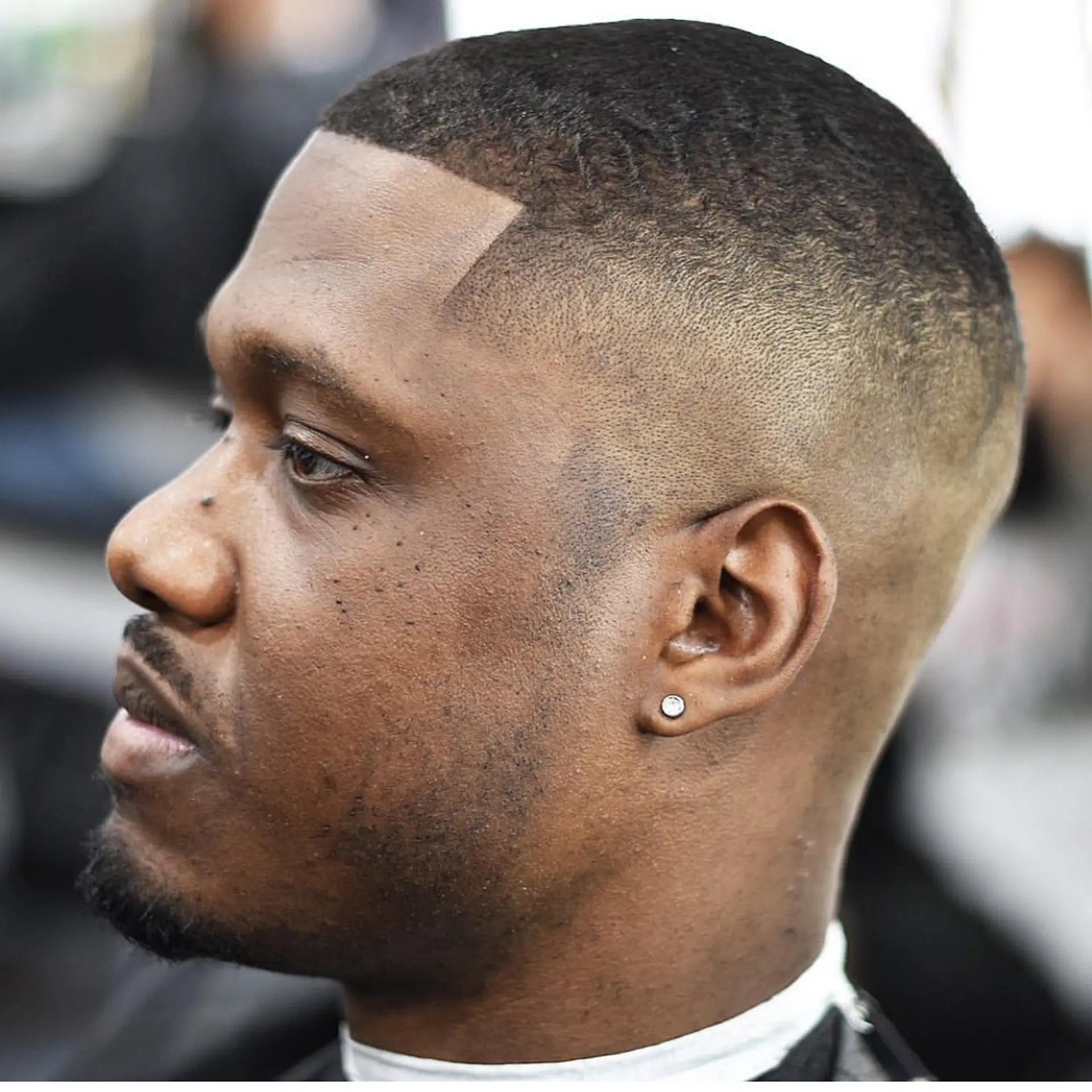A clean buzz cut paired with a precise skin fade and a sharp, defined edge-up. 1