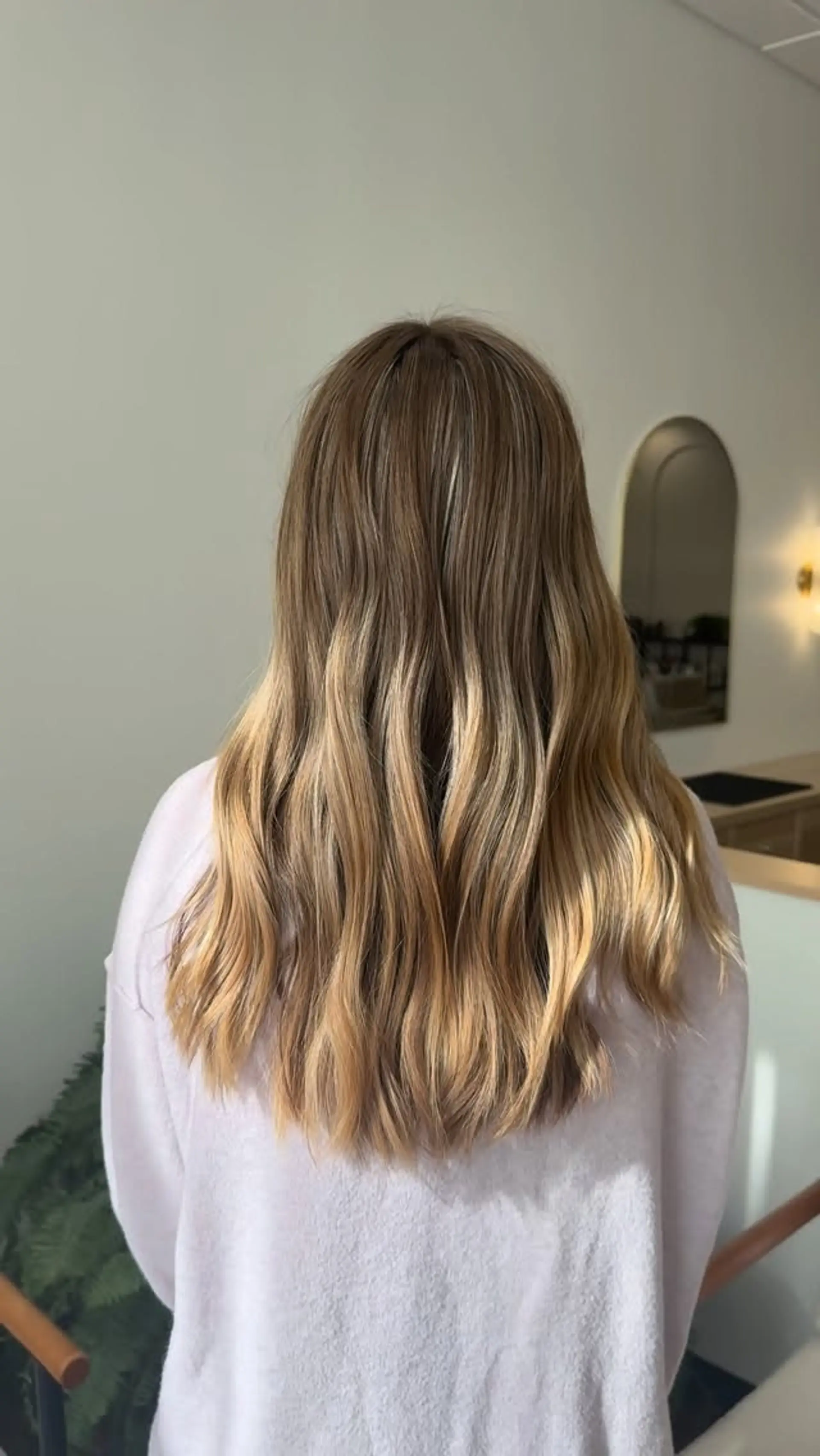 Long dimensional honey blonde balayage styled in soft, loose waves. 1