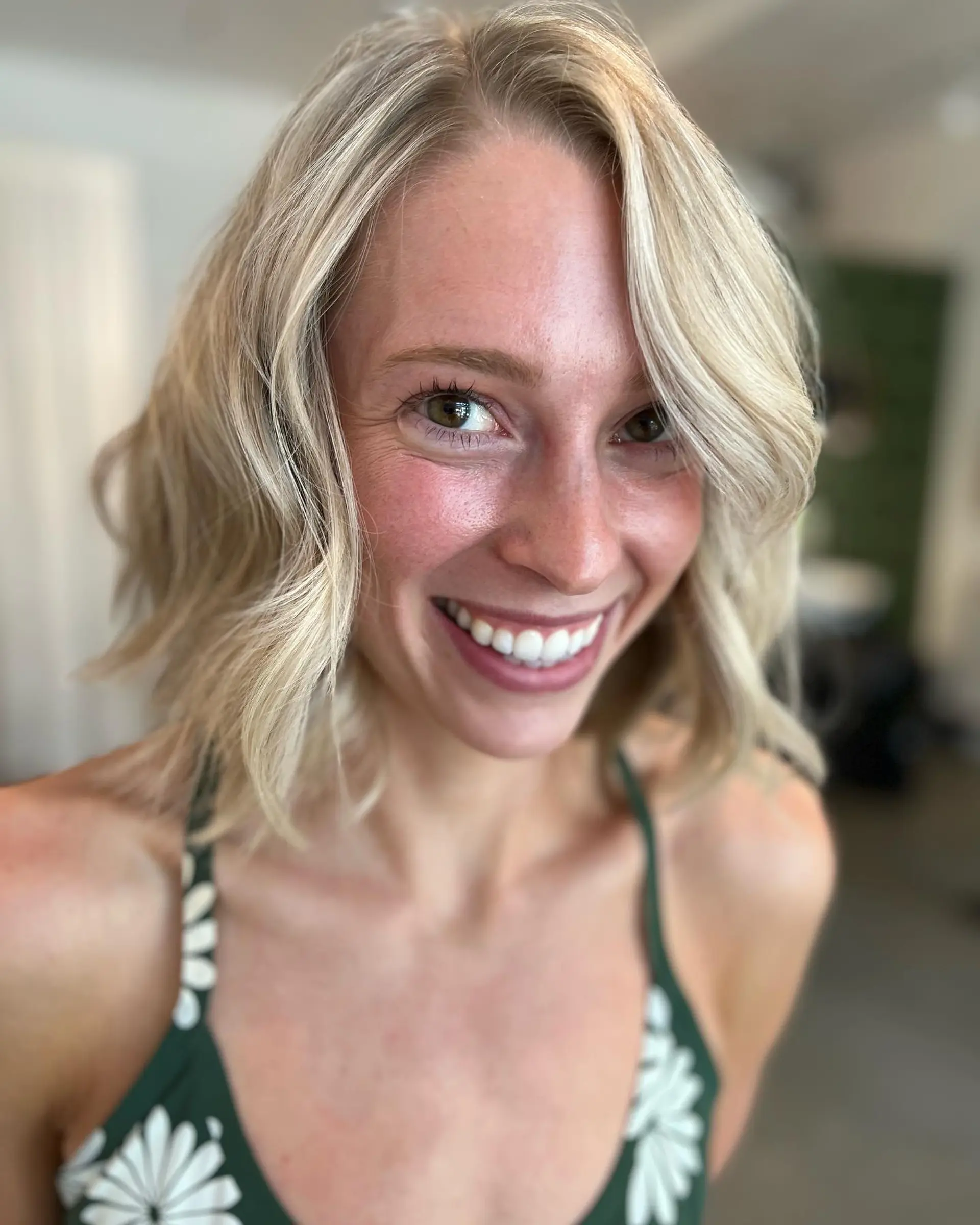 A textured chin-to-collarbone blonde bob styled with relaxed waves and a side part. 1