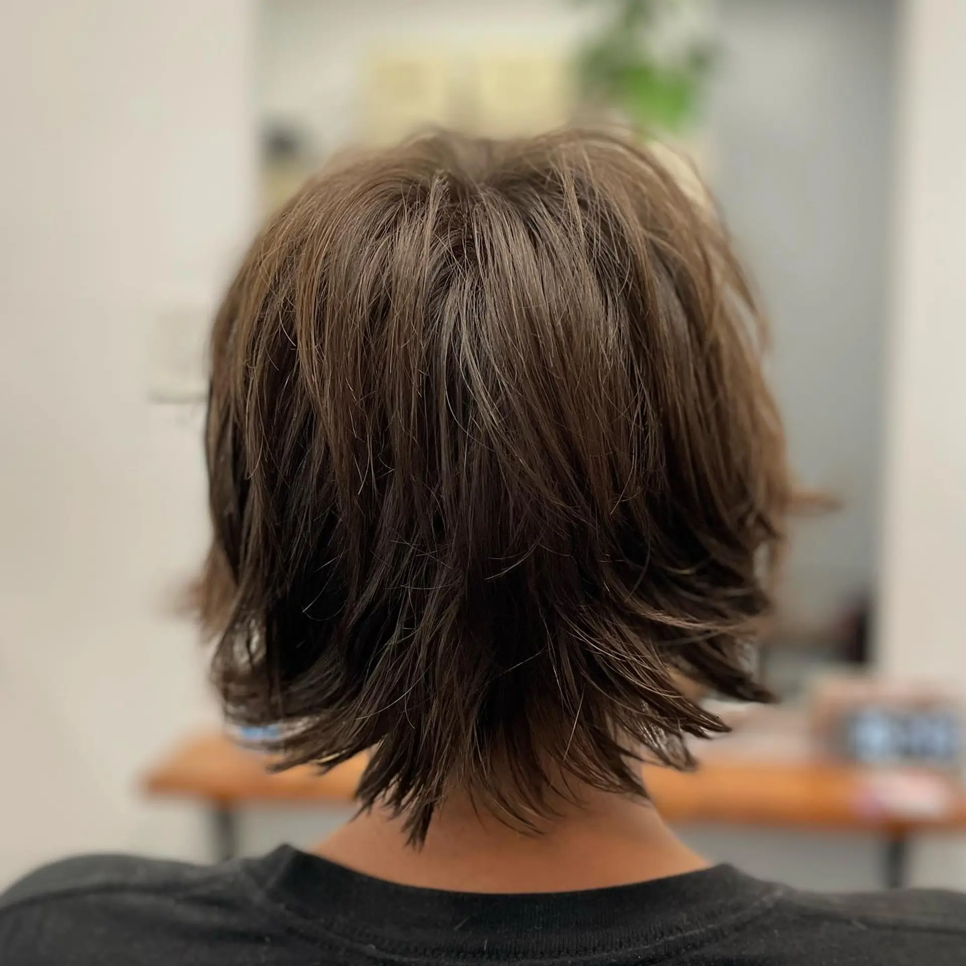 A textured short shag haircut featuring layered dimension and flicked ends around the nape. 1