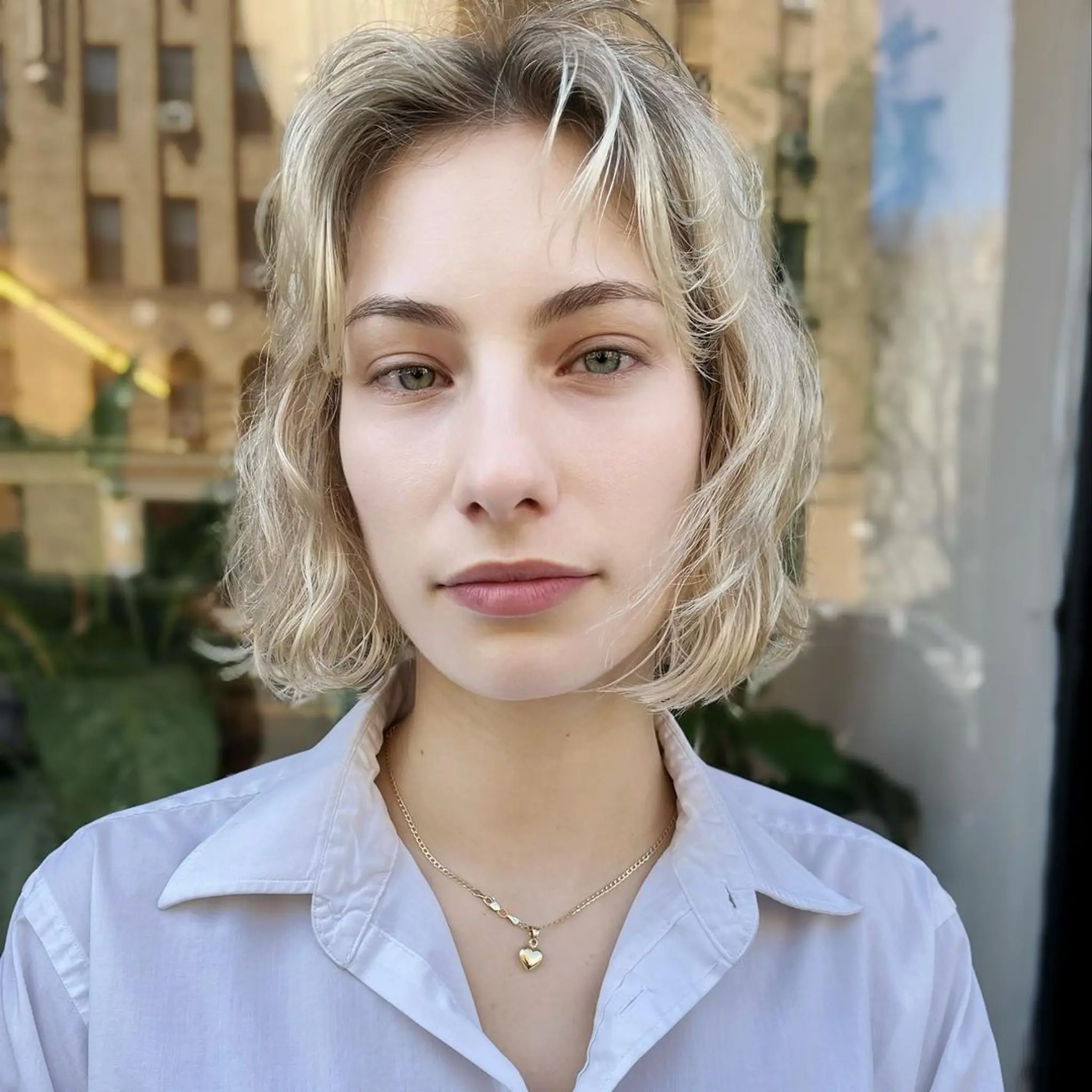 Short, wavy bob with platinum blonde highlights, layered ends, subtle fringe, and a side part. 1