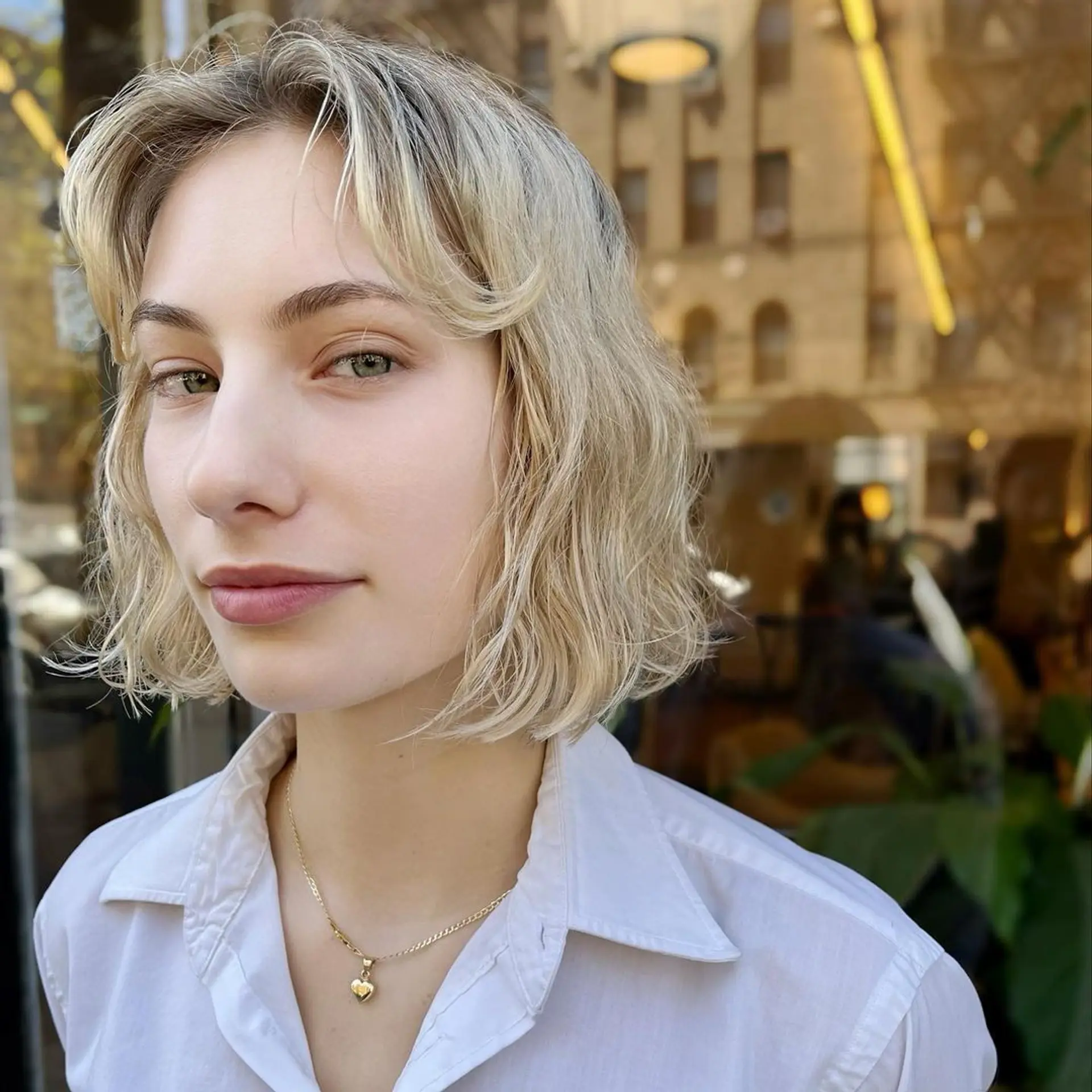 Short, wavy bob with platinum blonde highlights, layered ends, subtle fringe, and a side part. 2