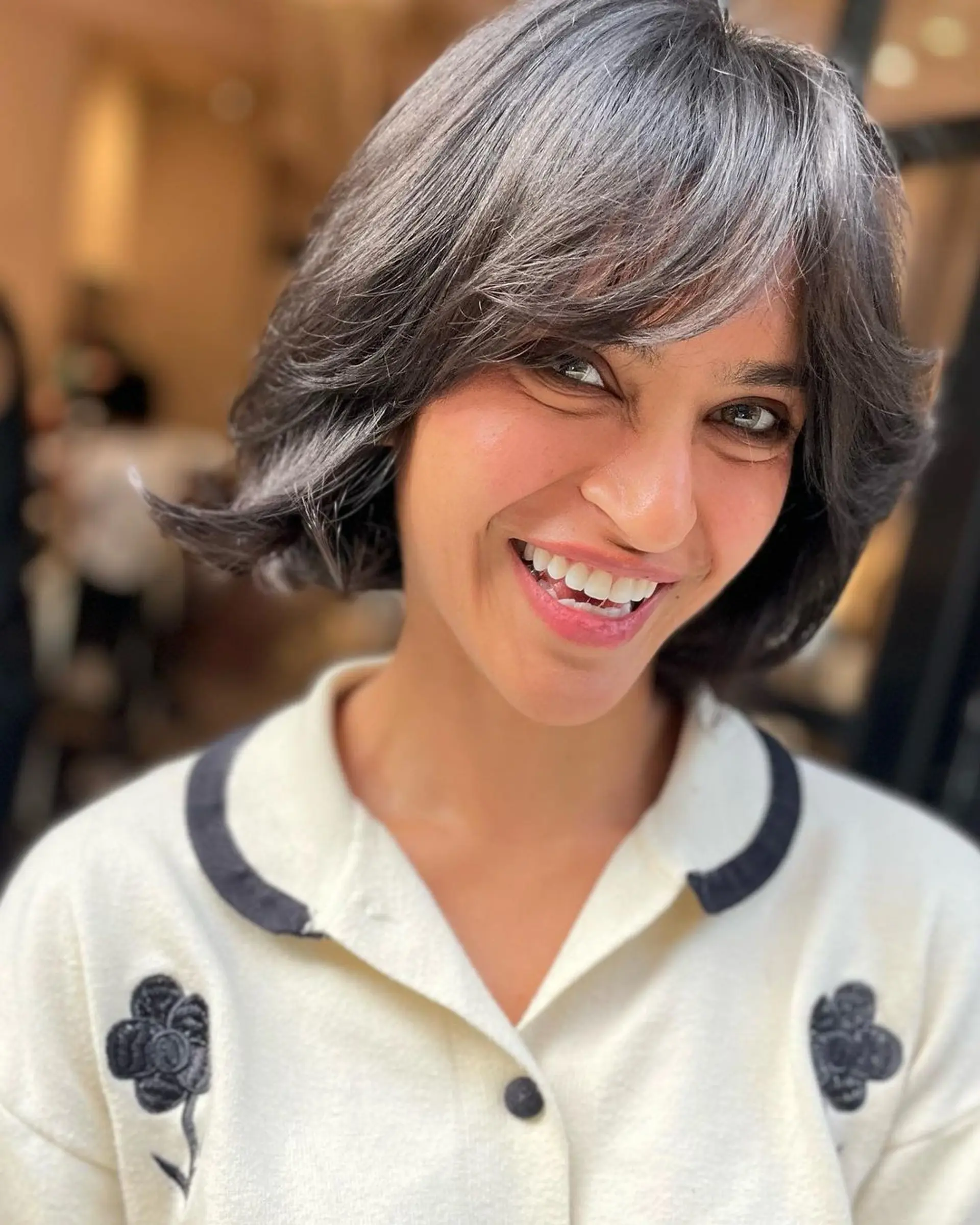 A stylish and modern short bob with a sophisticated blend of silver and grey. The straight hair features a side-swept fringe and layered sections for added movement and depth. 2