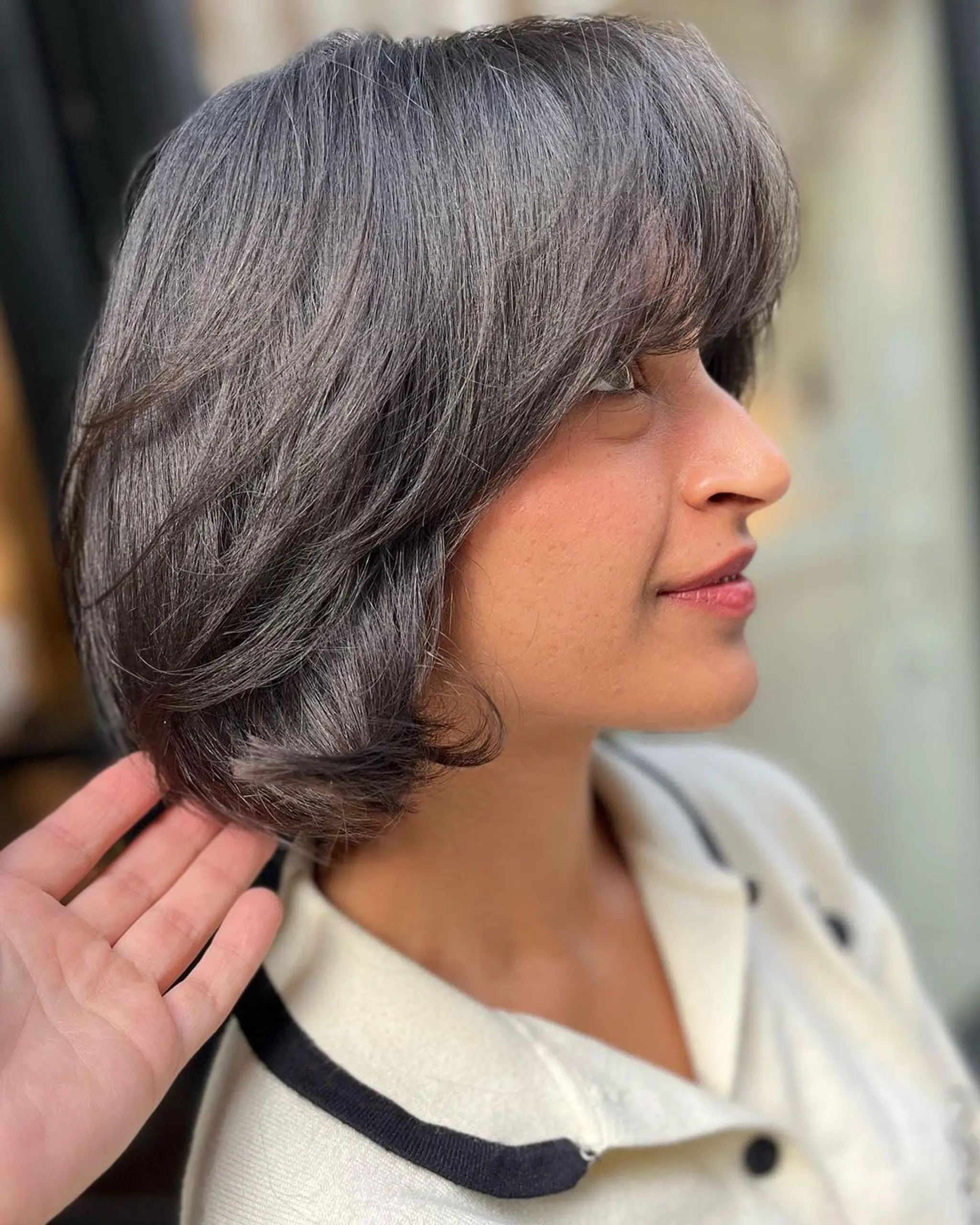 A stylish and modern short bob with a sophisticated blend of silver and grey. The straight hair features a side-swept fringe and layered sections for added movement and depth. 3