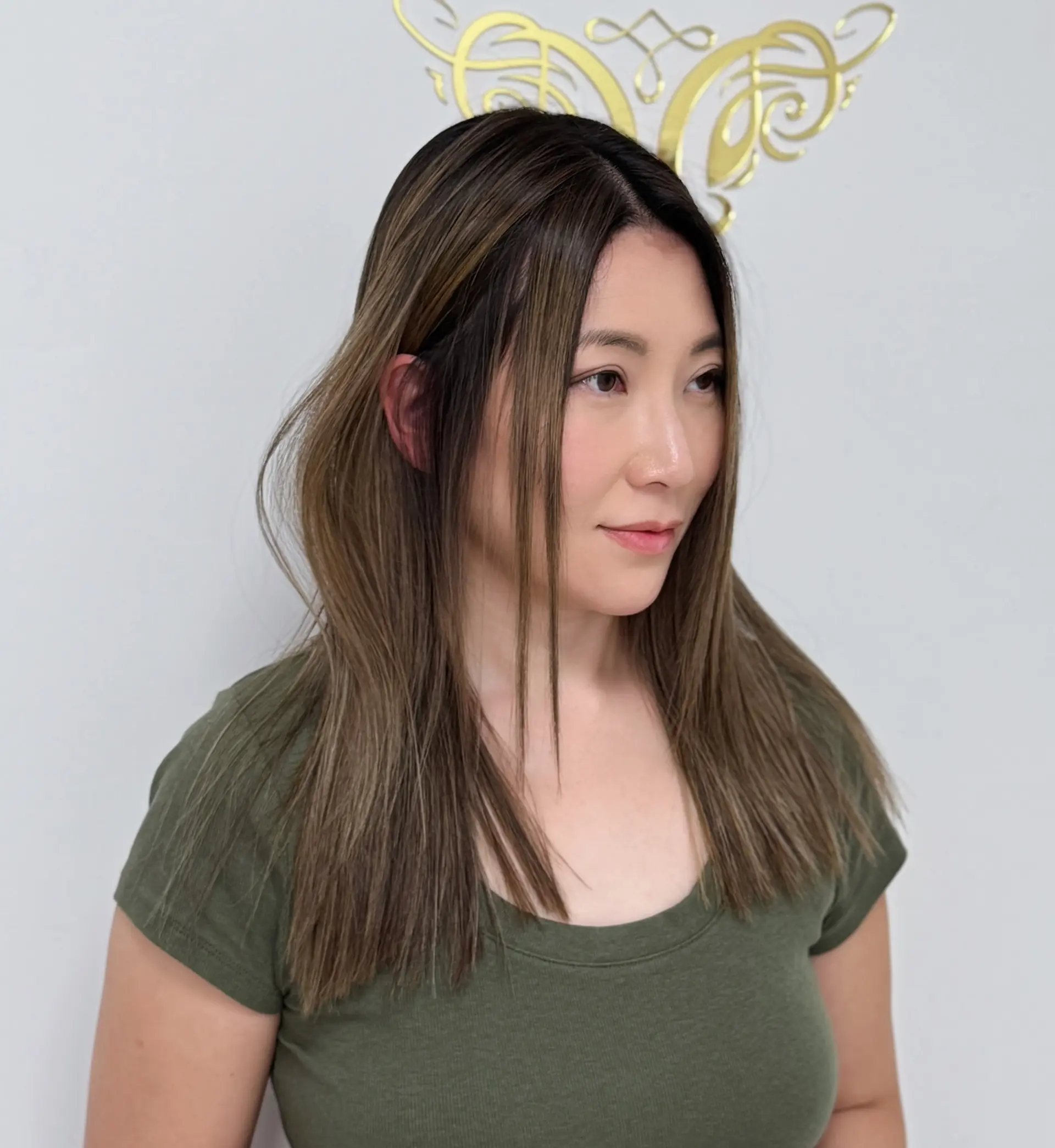 A silky straight medium-length hairstyle with a brunette balayage and subtle blonde highlights. 1