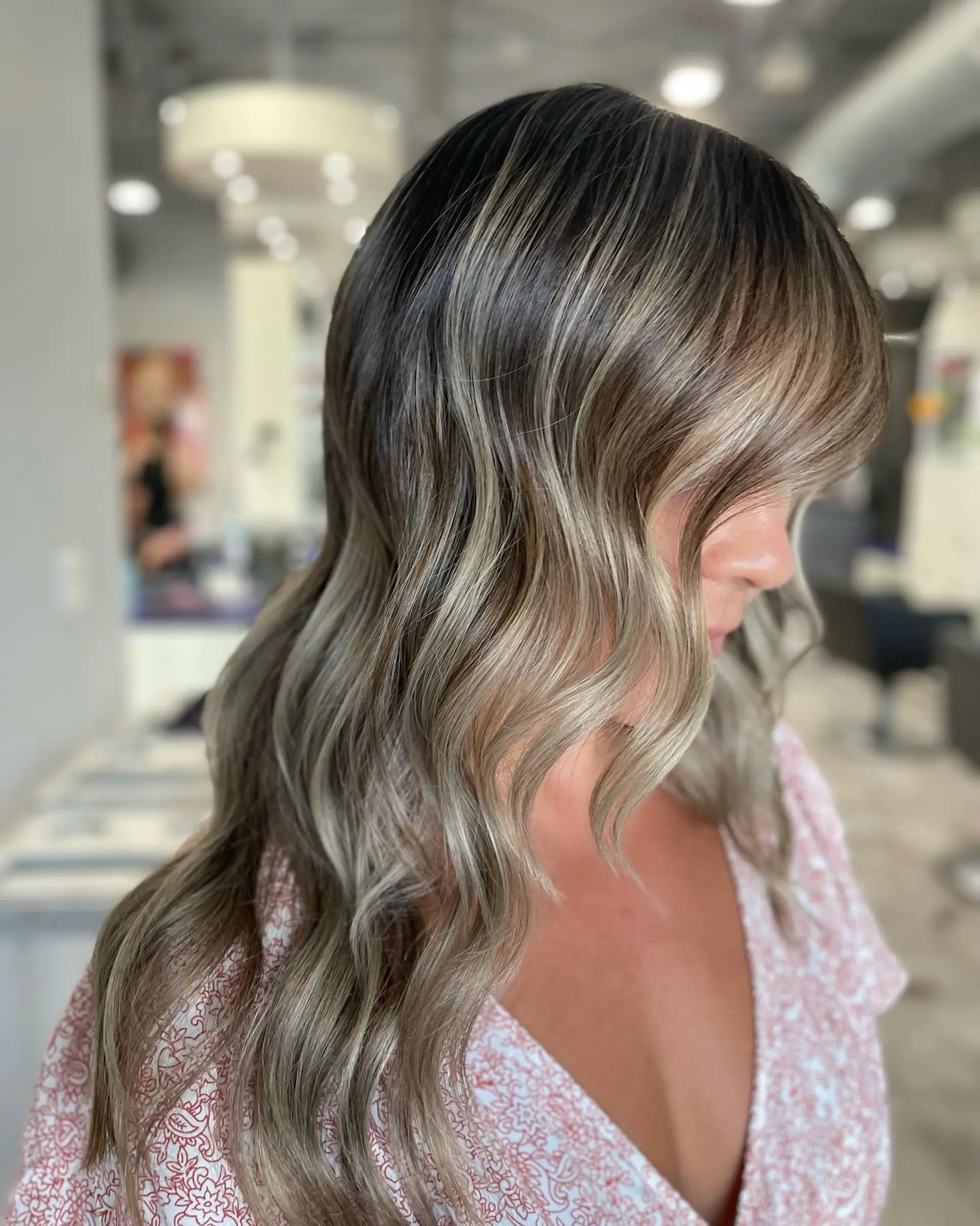 A long, wavy hairstyle with ash blonde balayage and soft curtain bangs. 1