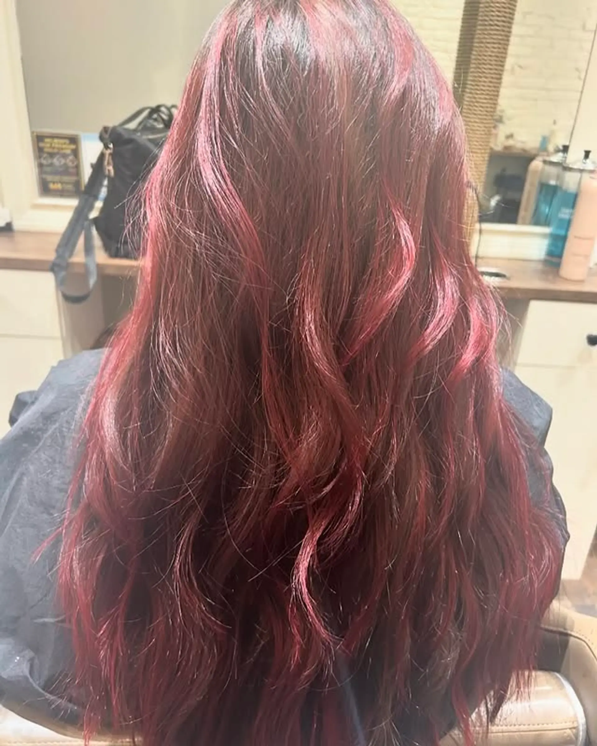 A long wavy hairstyle with a burgundy balayage. 1