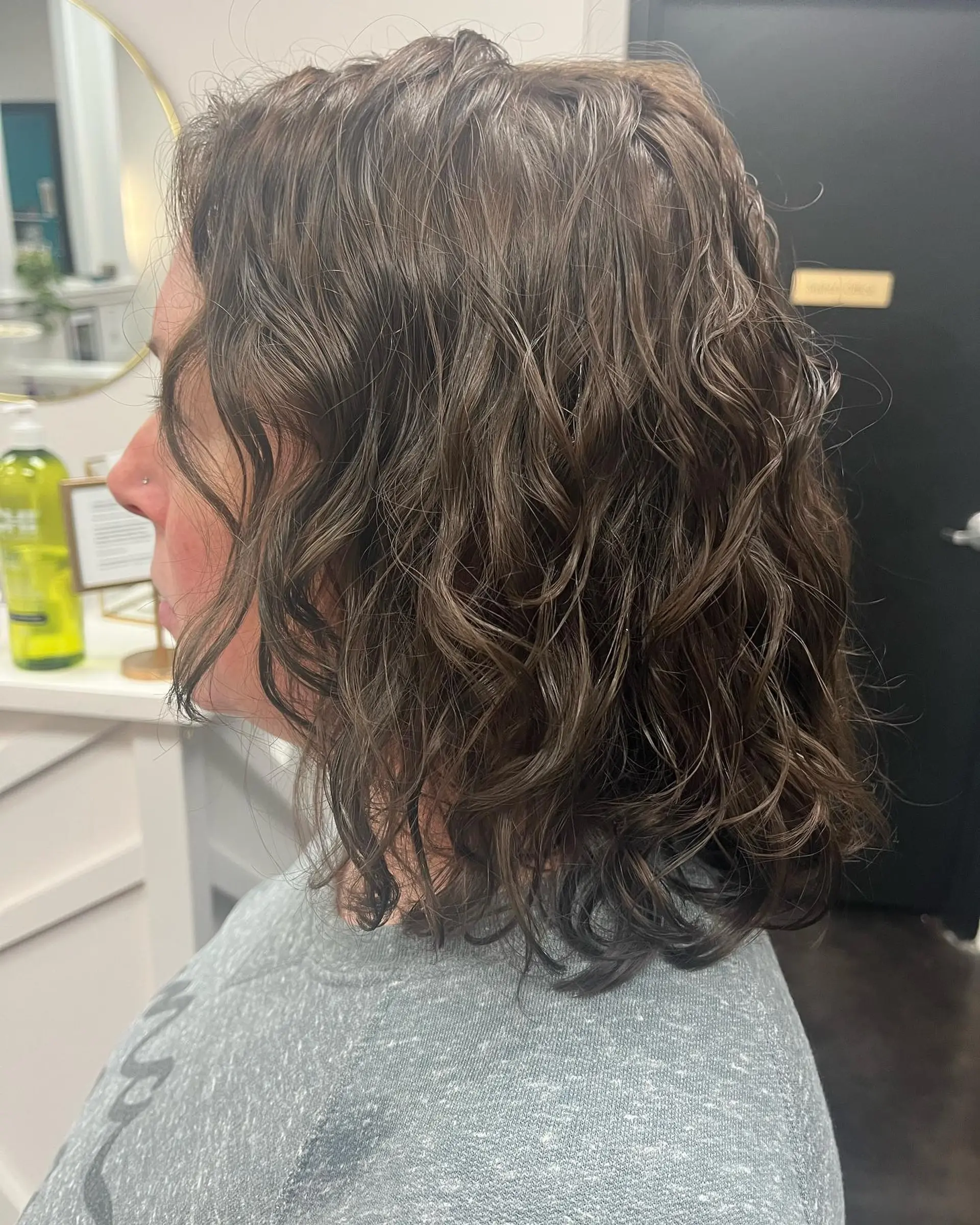 A shoulder-length layered curly lob styled with defined, natural curls and a rich brunette tone. 1