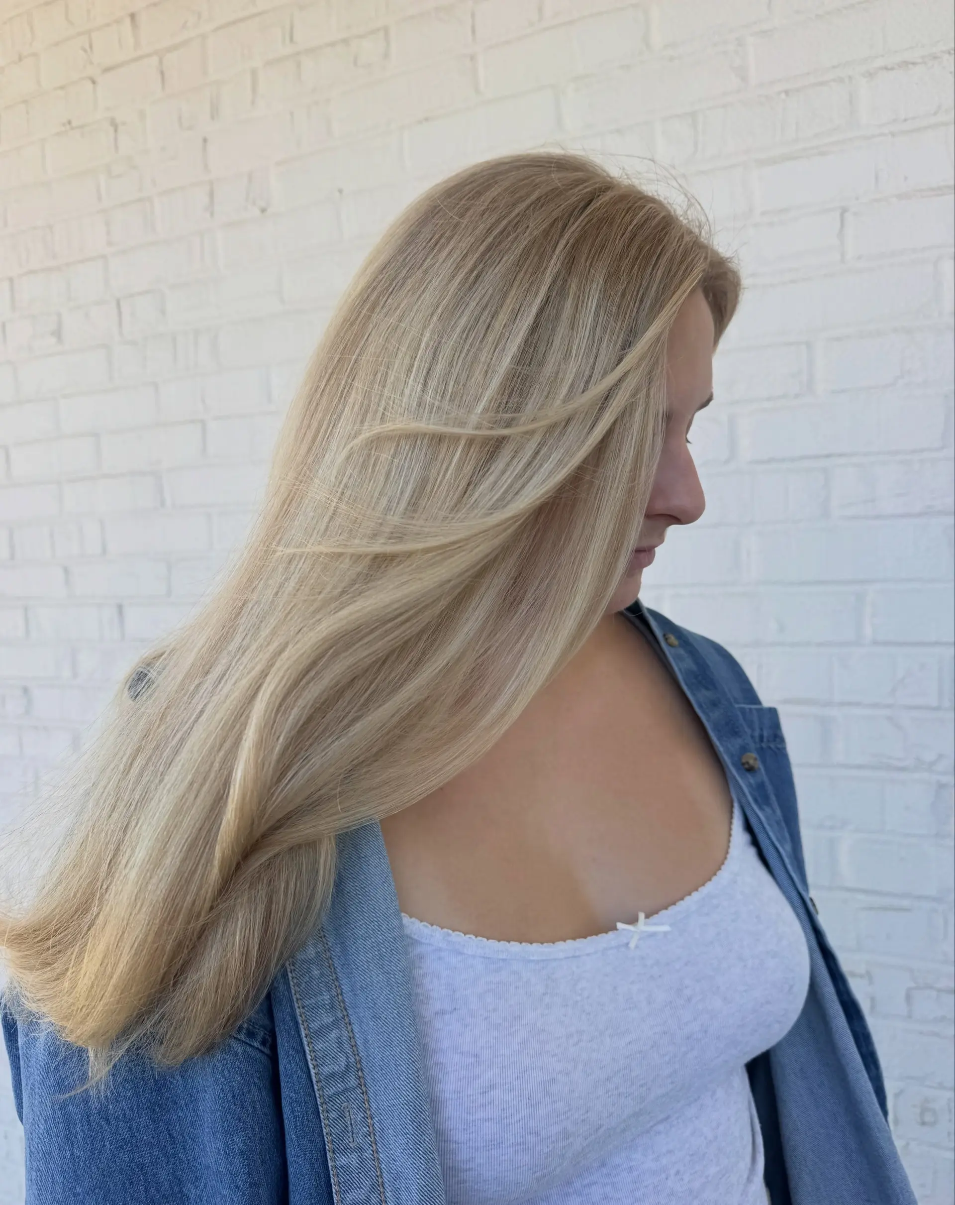 Long, silky blonde hair featuring fine multi-tonal highlights, styled straight with soft movement and face-framing layers. 1