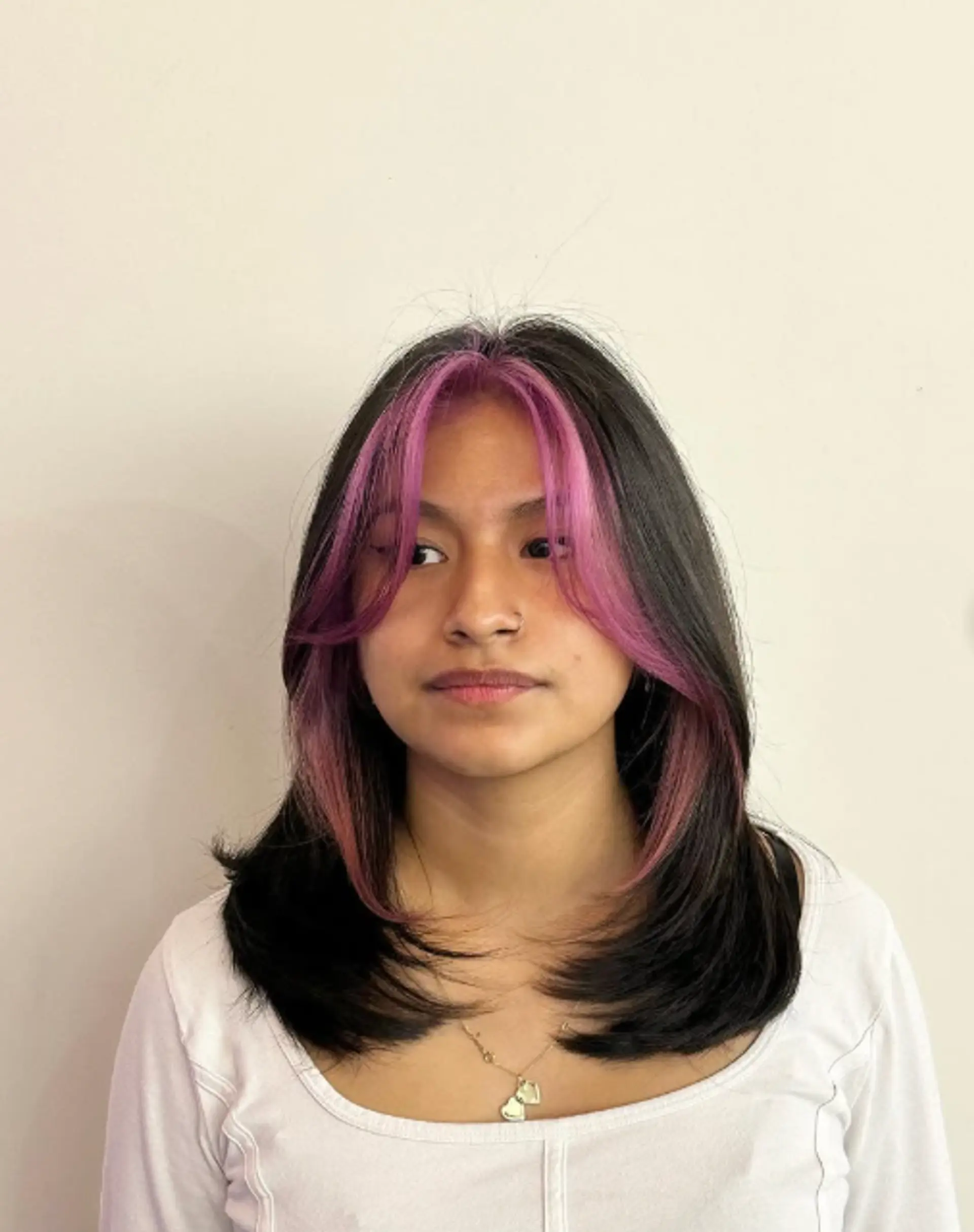 A layered medium-length hairstyle with face-framing layers and bright money piece highlights. 1