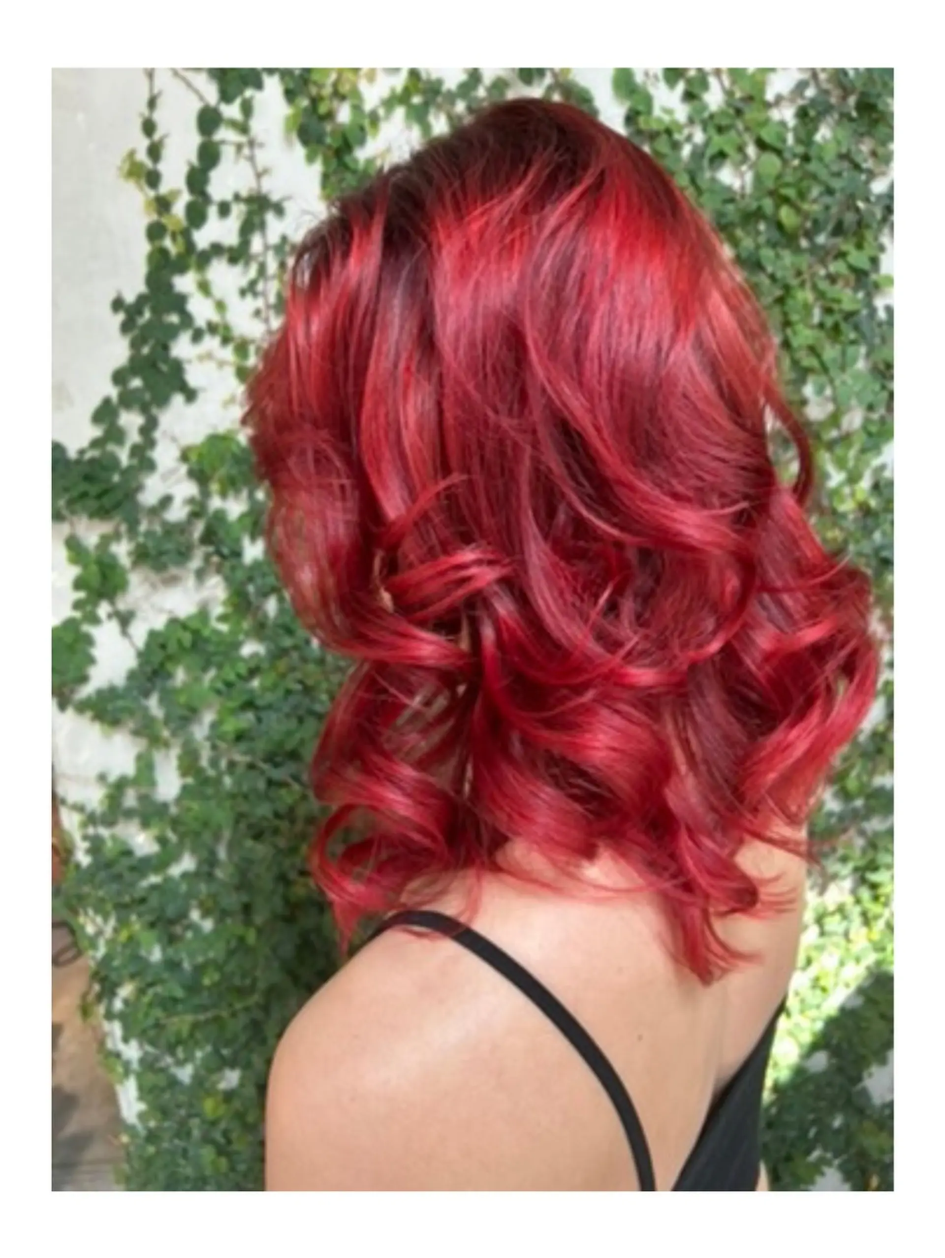 Vibrant crimson red hair styled in voluminous, polished waves resting at shoulder length. 1