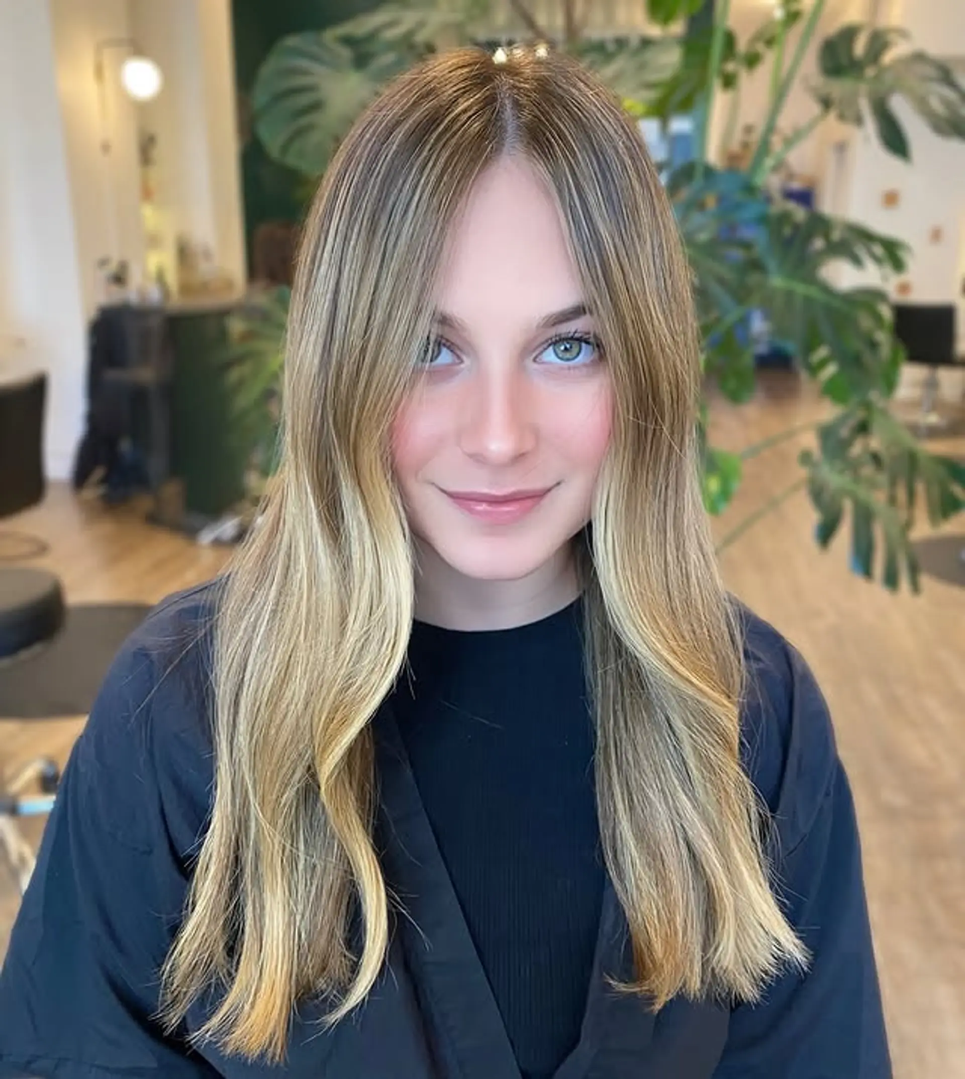 A layered long hairstyle with soft, beachy waves and face-framing layers. 1