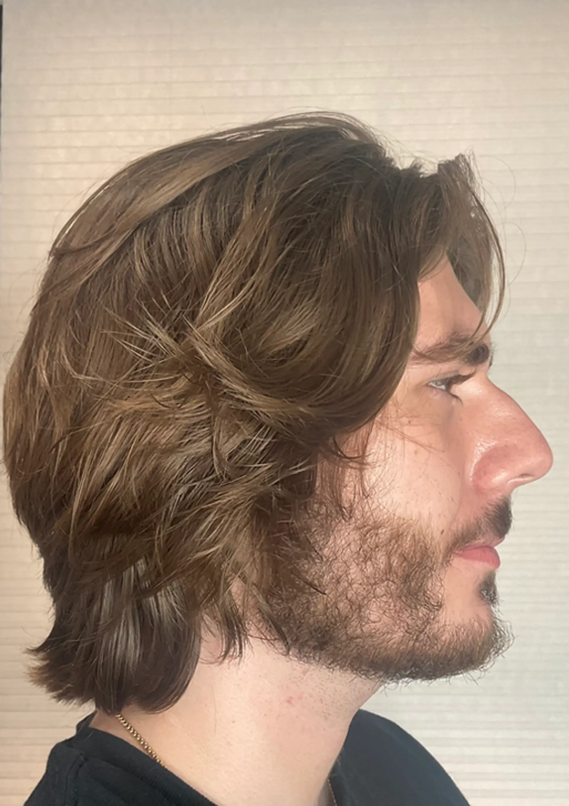 The hairstyle features light brown, wavy, medium-length hair. It is layered with a side-sweep, giving a natural and casual look with its flowing waves. 1