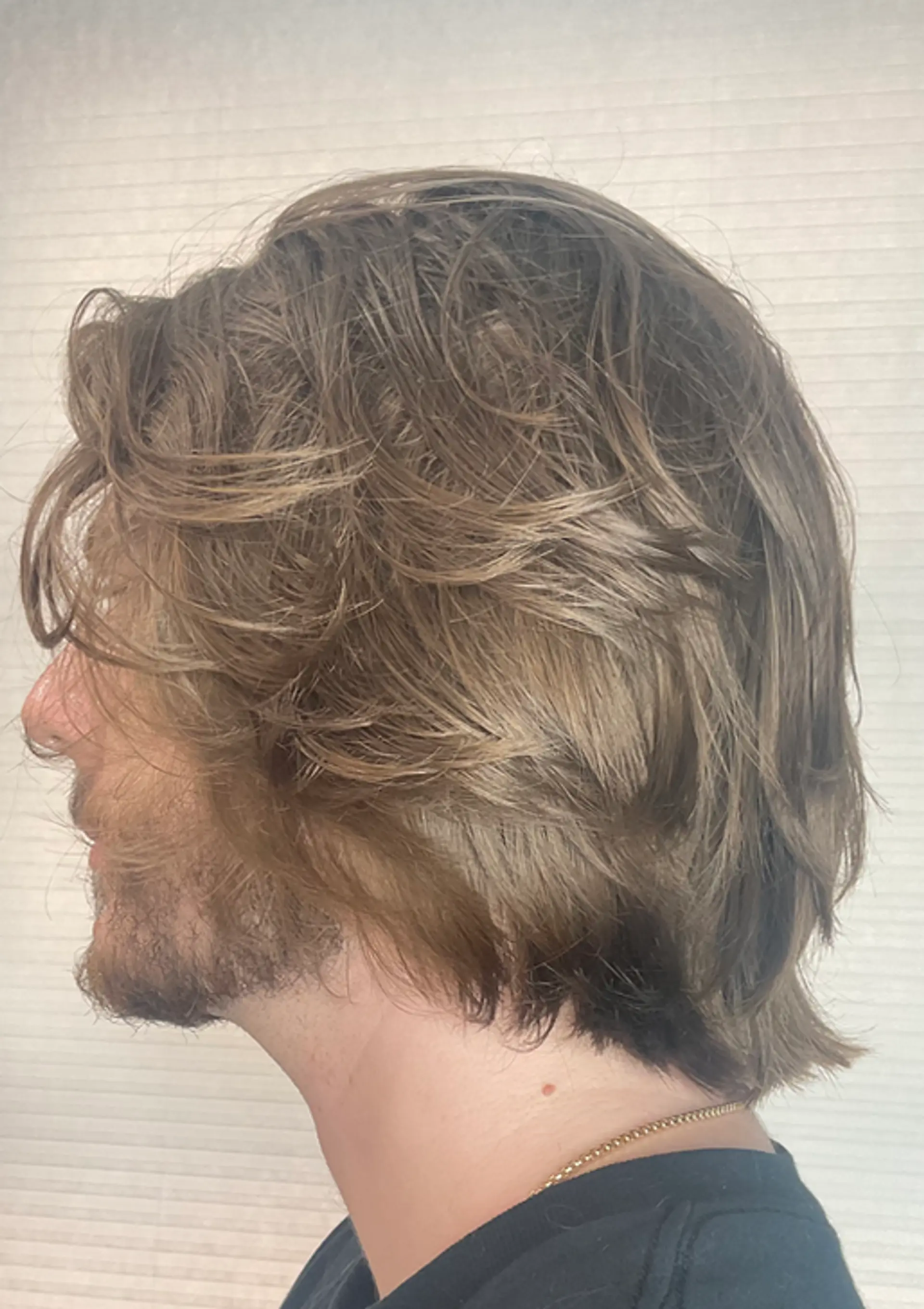 The hairstyle features light brown, wavy, medium-length hair. It is layered with a side-sweep, giving a natural and casual look with its flowing waves. 2