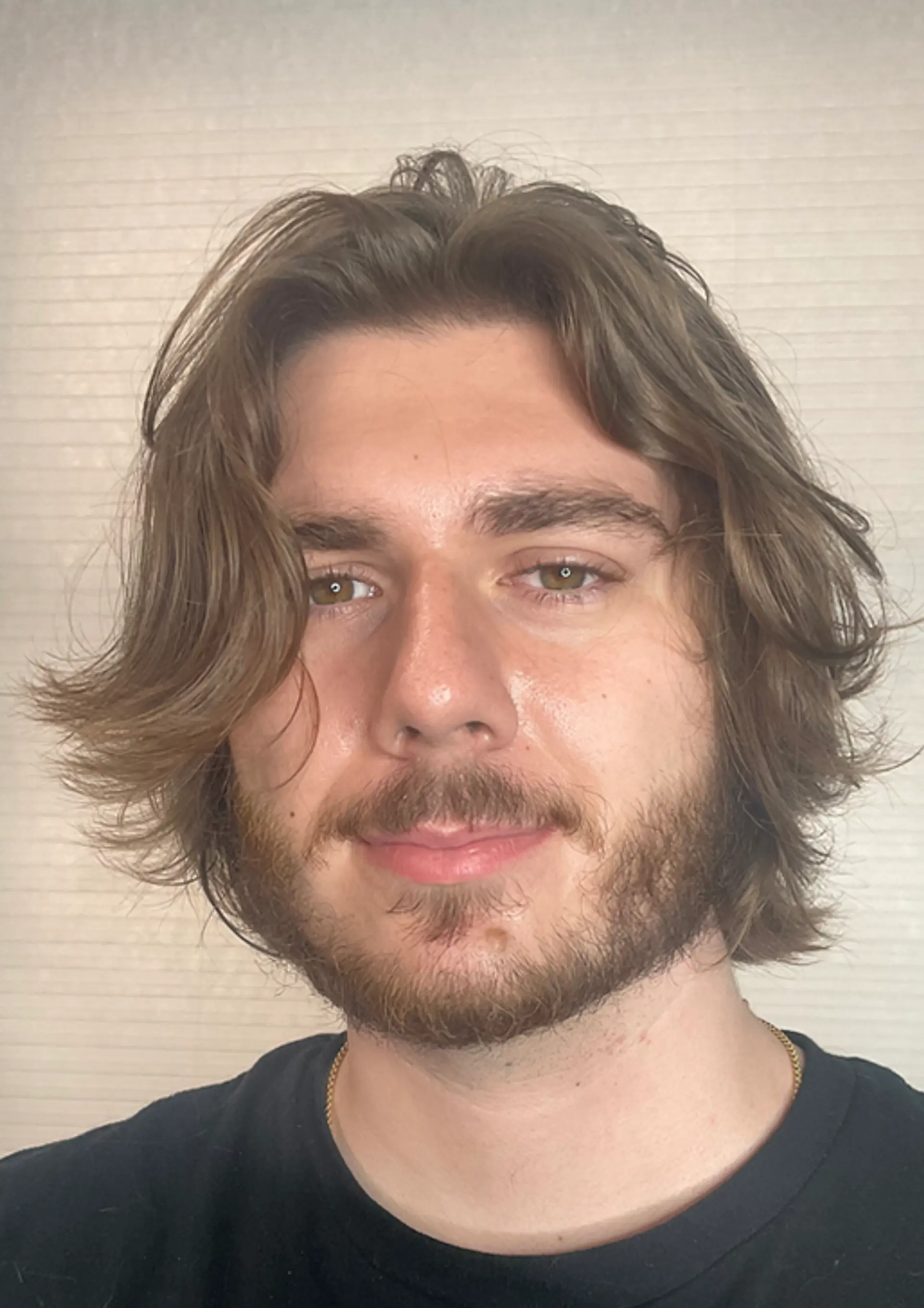 The hairstyle features light brown, wavy, medium-length hair. It is layered with a side-sweep, giving a natural and casual look with its flowing waves. 3