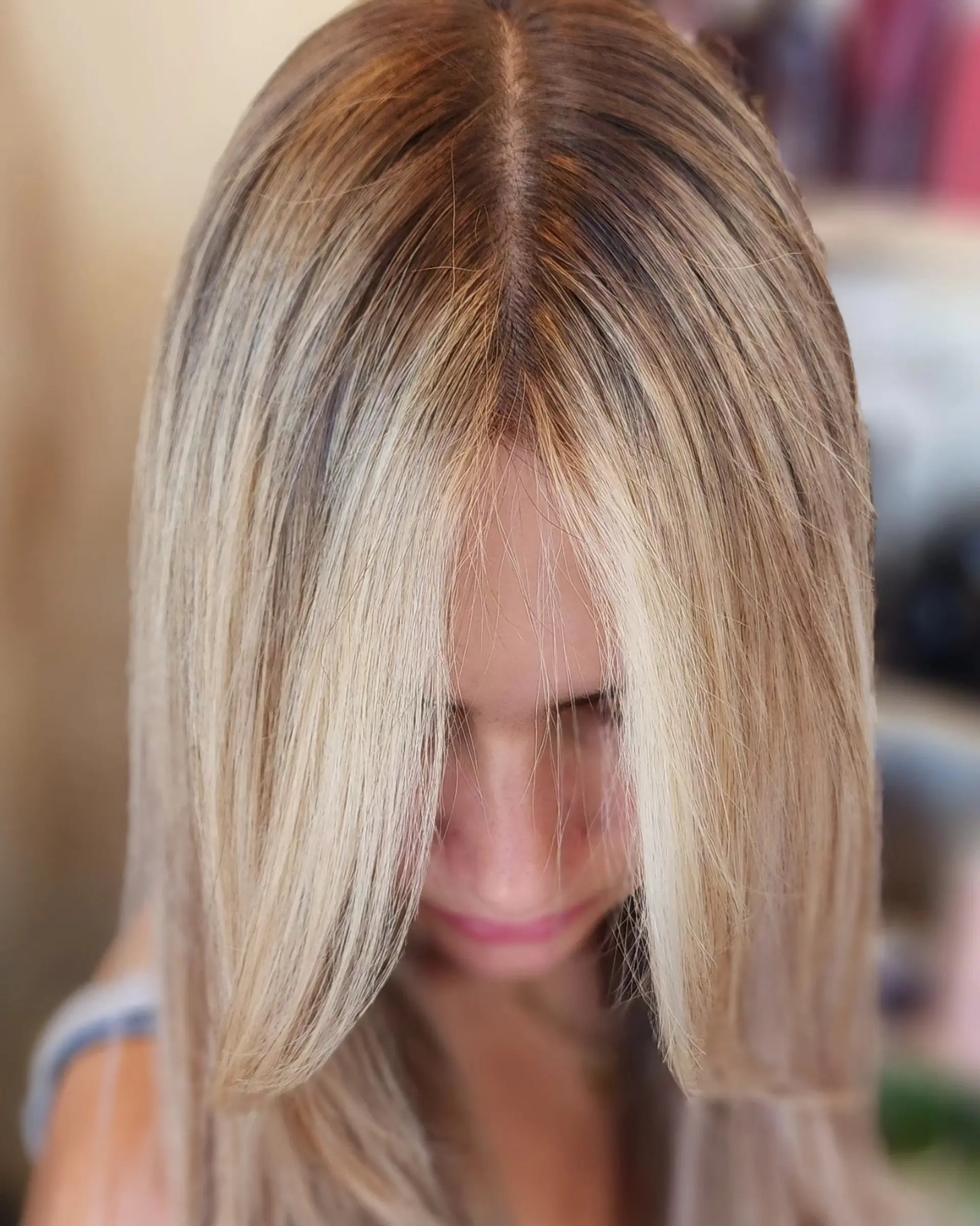 A lived-in blonde look with a soft shadow root, dimensional highlights, and bright face-framing money pieces styled straight. 1