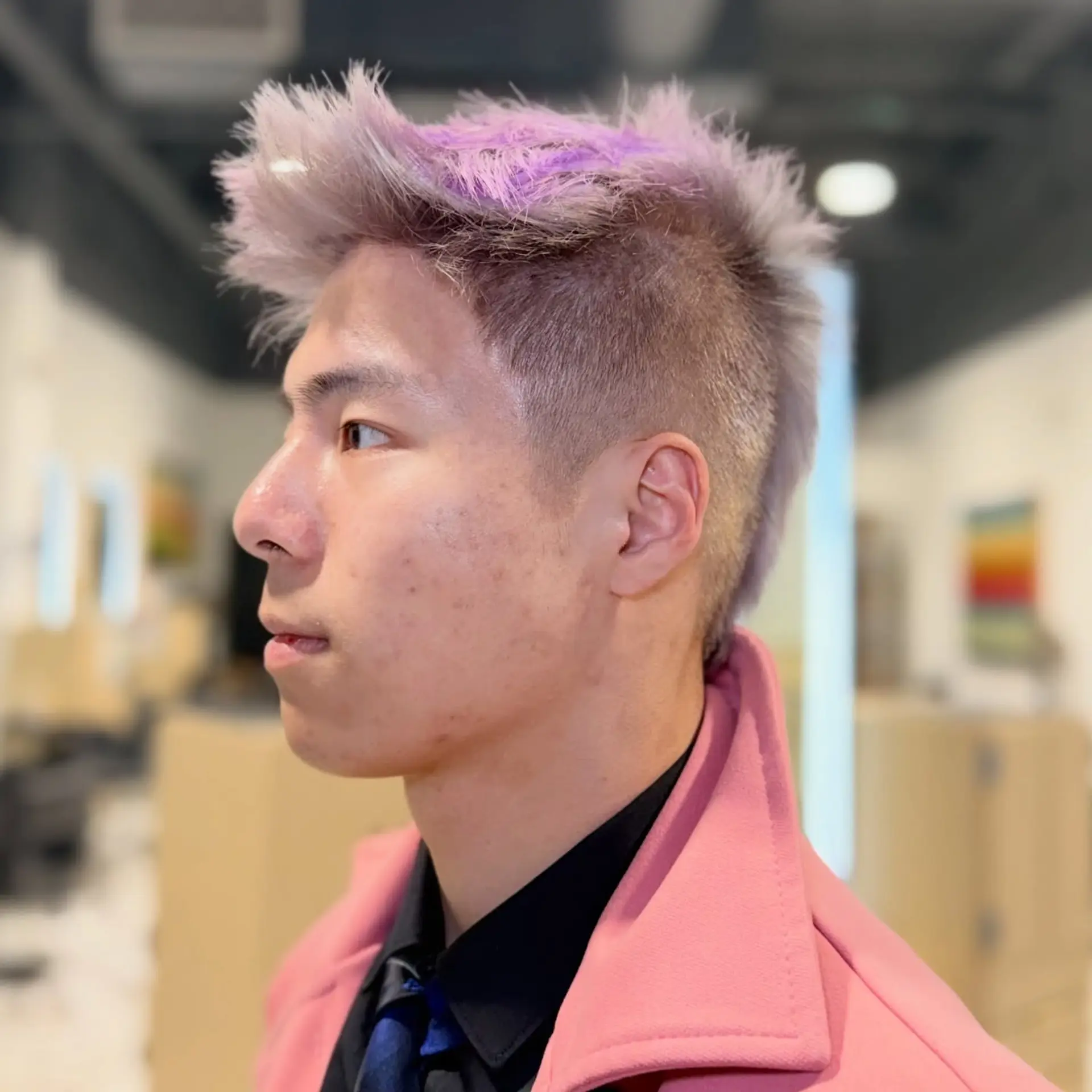 A textured short faux hawk haircut with short faded sides and spiky, pastel lavender-toned hair on top. 1