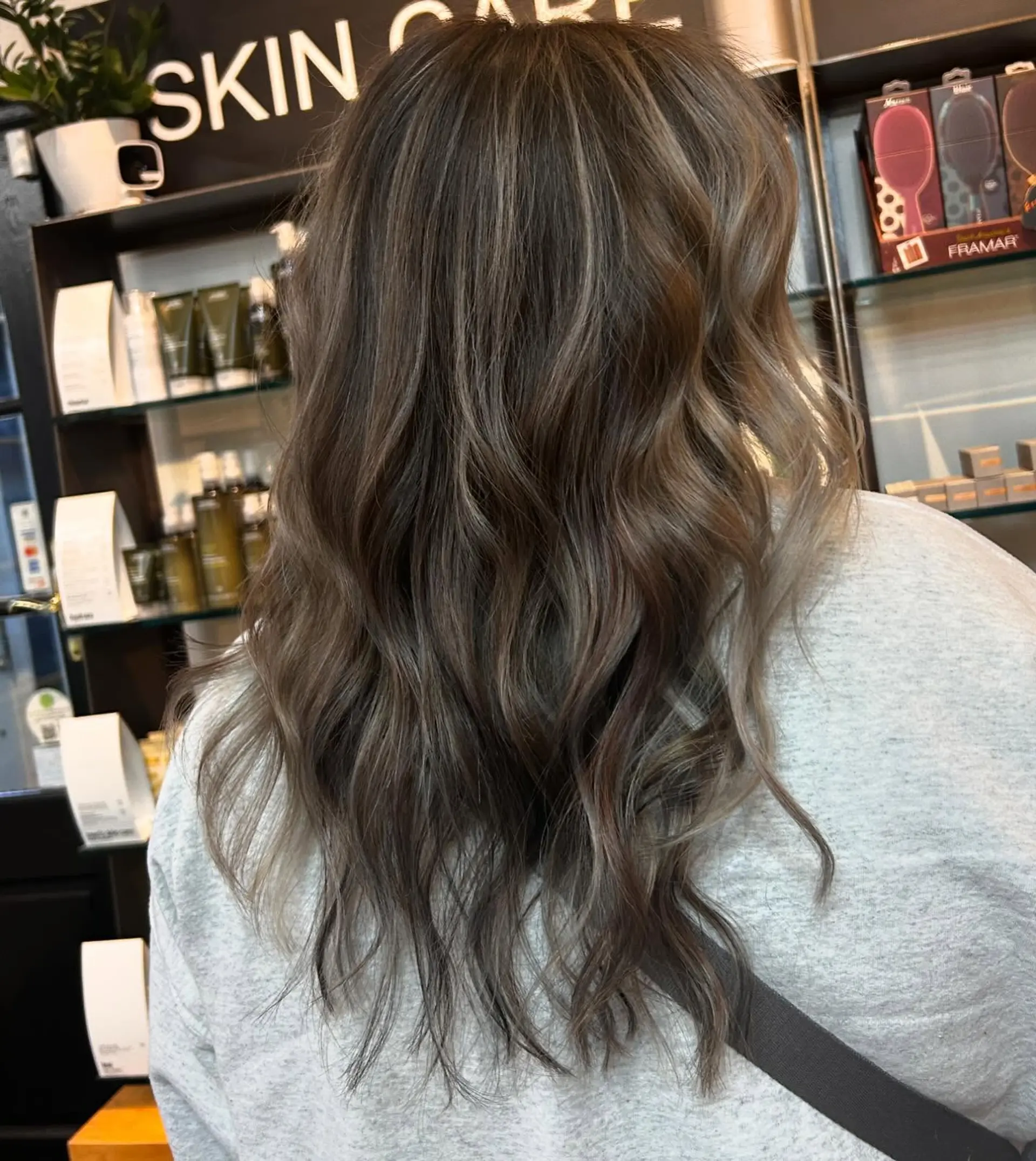 Long, flowing hair styled in loose beach waves with a natural, blended cool-toned ash brown and beige blonde balayage. 1