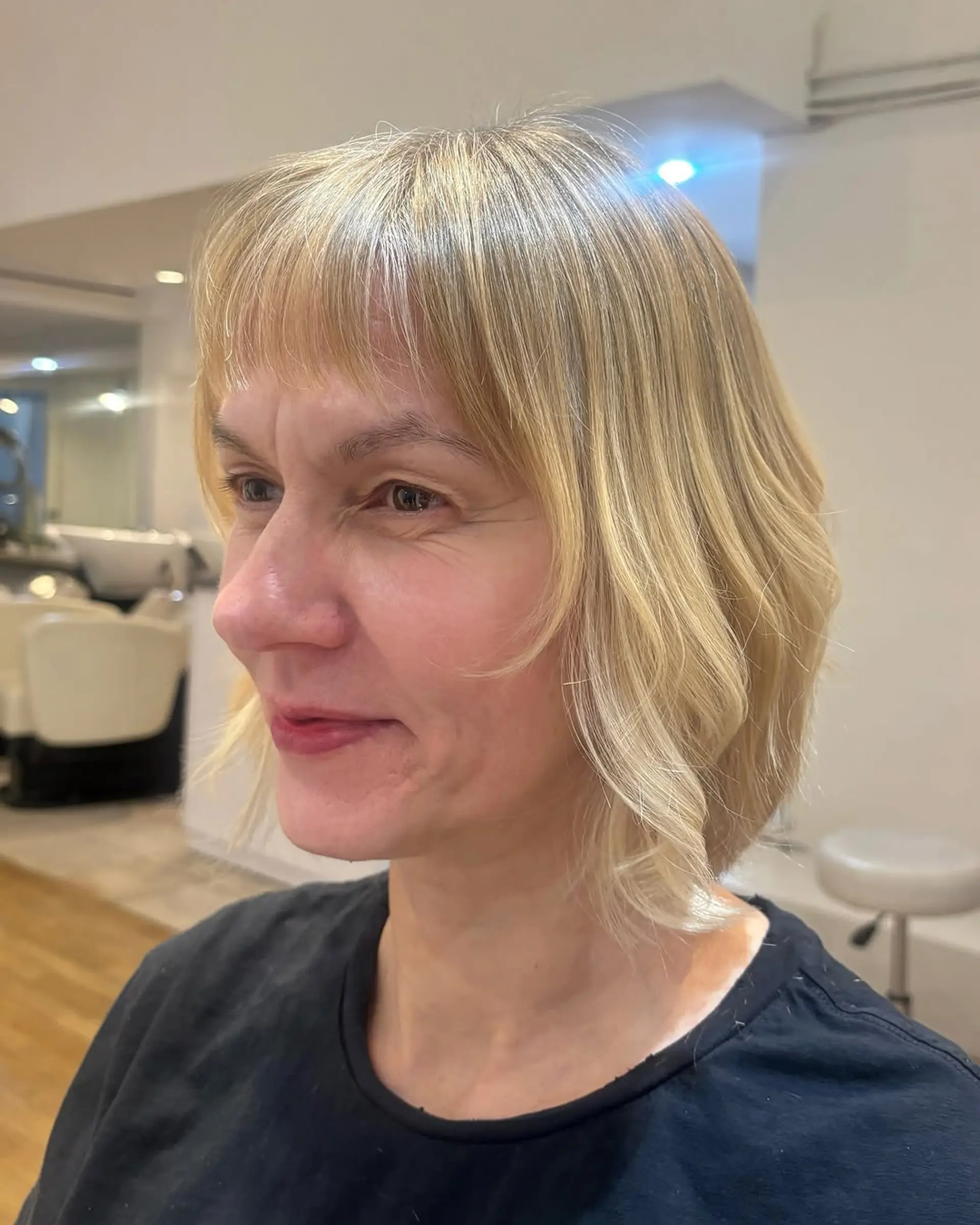 A shoulder-length bob with face-framing curtain bangs and soft waves. 1