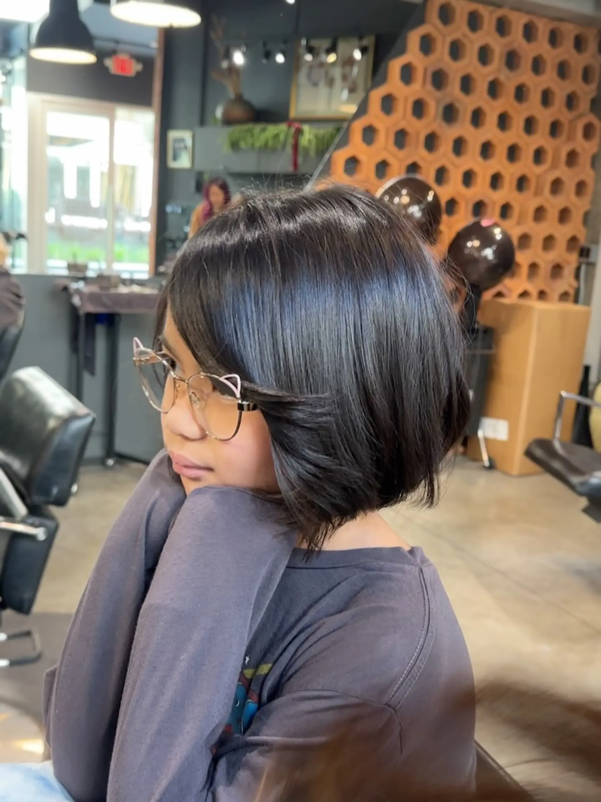 A glossy chin-length bob haircut featuring textured ends and feathered, swept-back face-framing layers. 1
