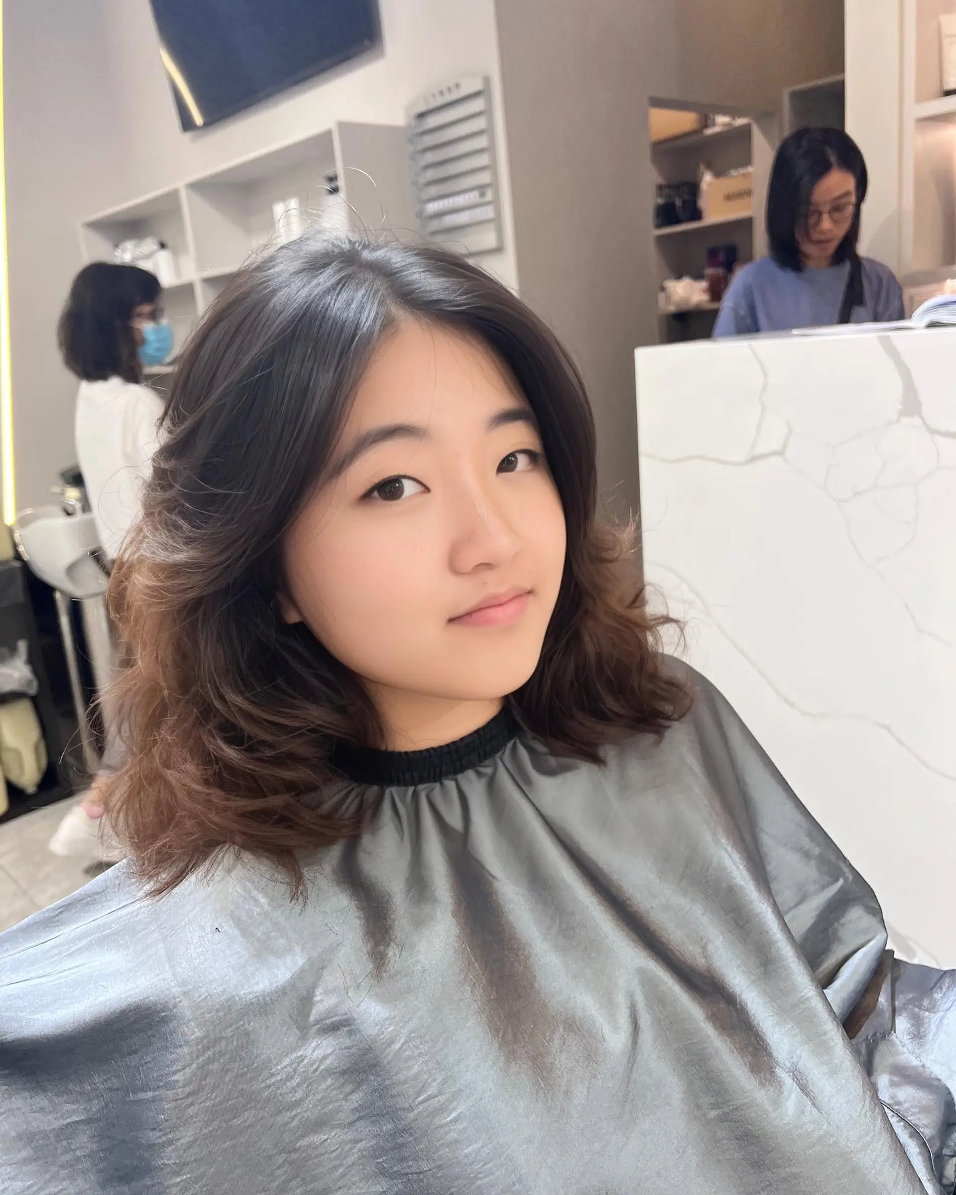 A medium length wavy hairstyle with a bronzed balayage and soft layers. 1