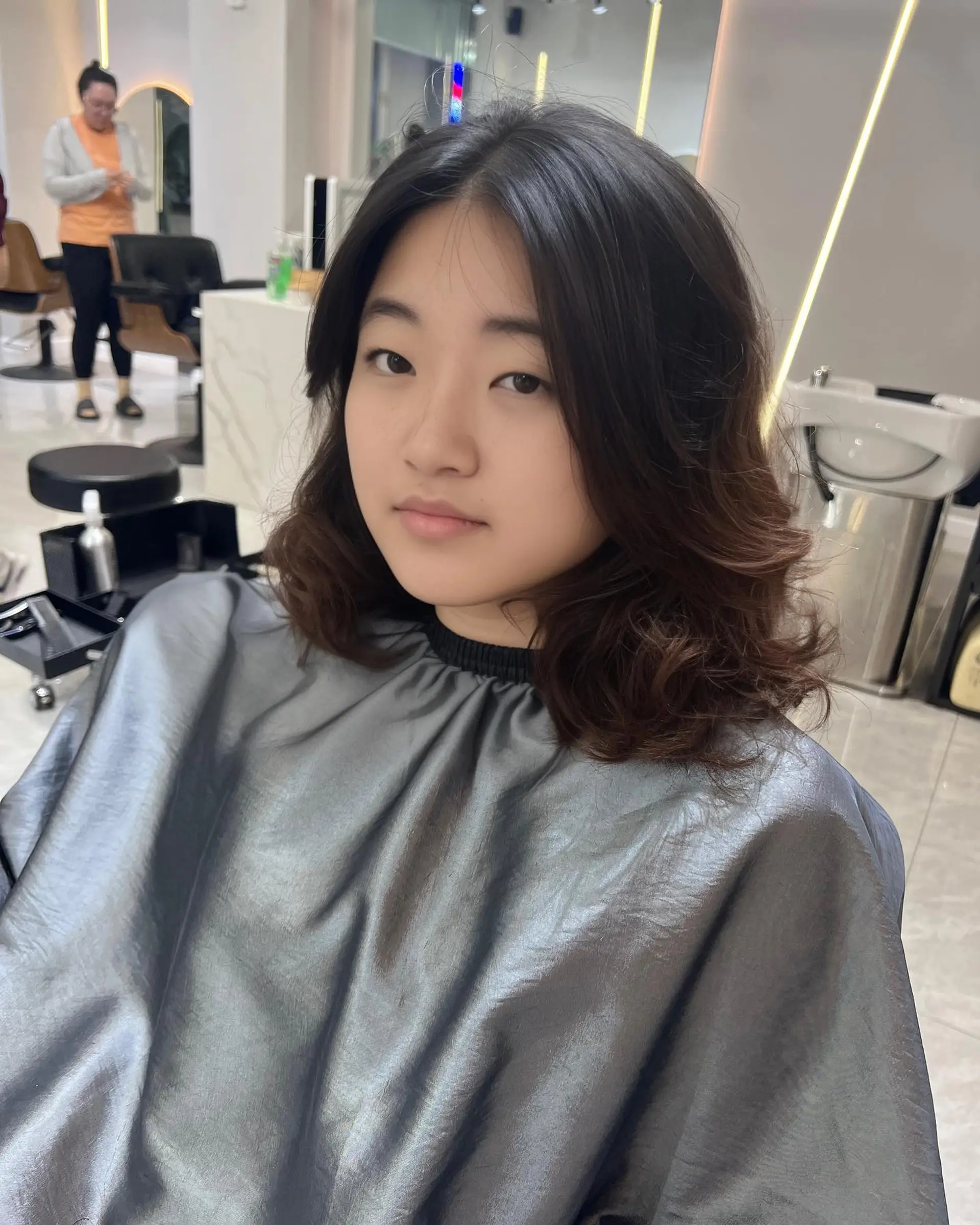 A medium length wavy hairstyle with a bronzed balayage and soft layers. 2