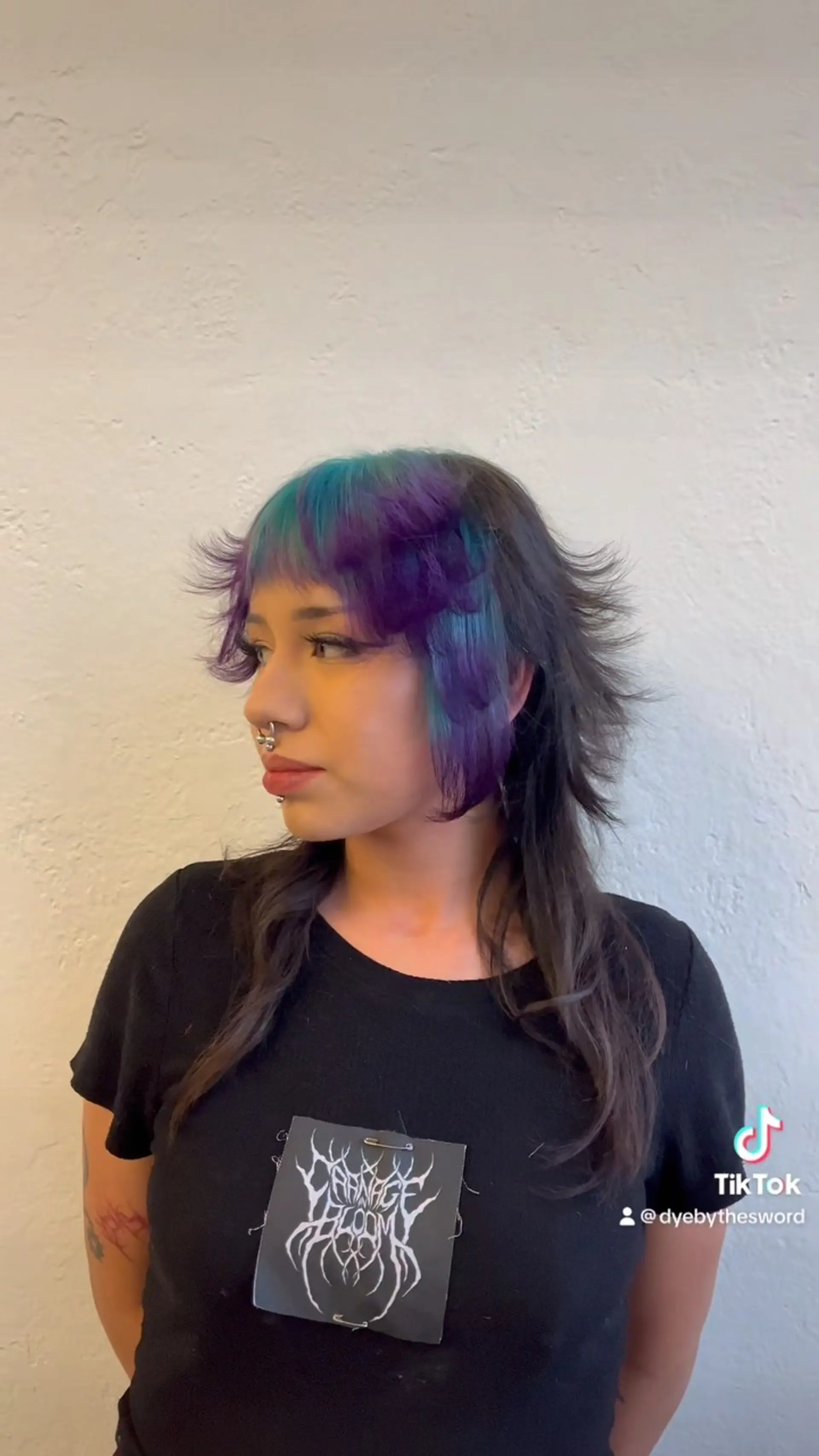 A feathered shag mullet cut featuring textured, flicked-out layers and vibrant purple and teal color-blocked bangs and face-framing pieces. 1