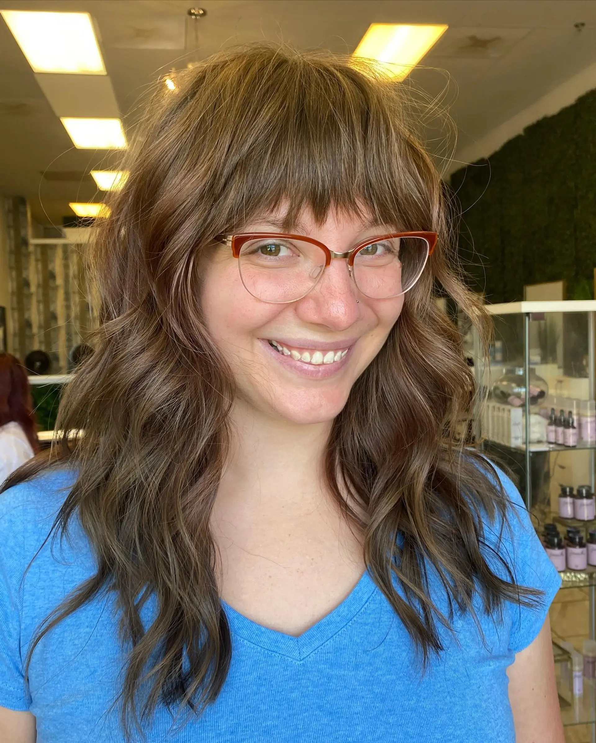 A modern shaggy haircut featuring long, wavy layers and full bangs. 1