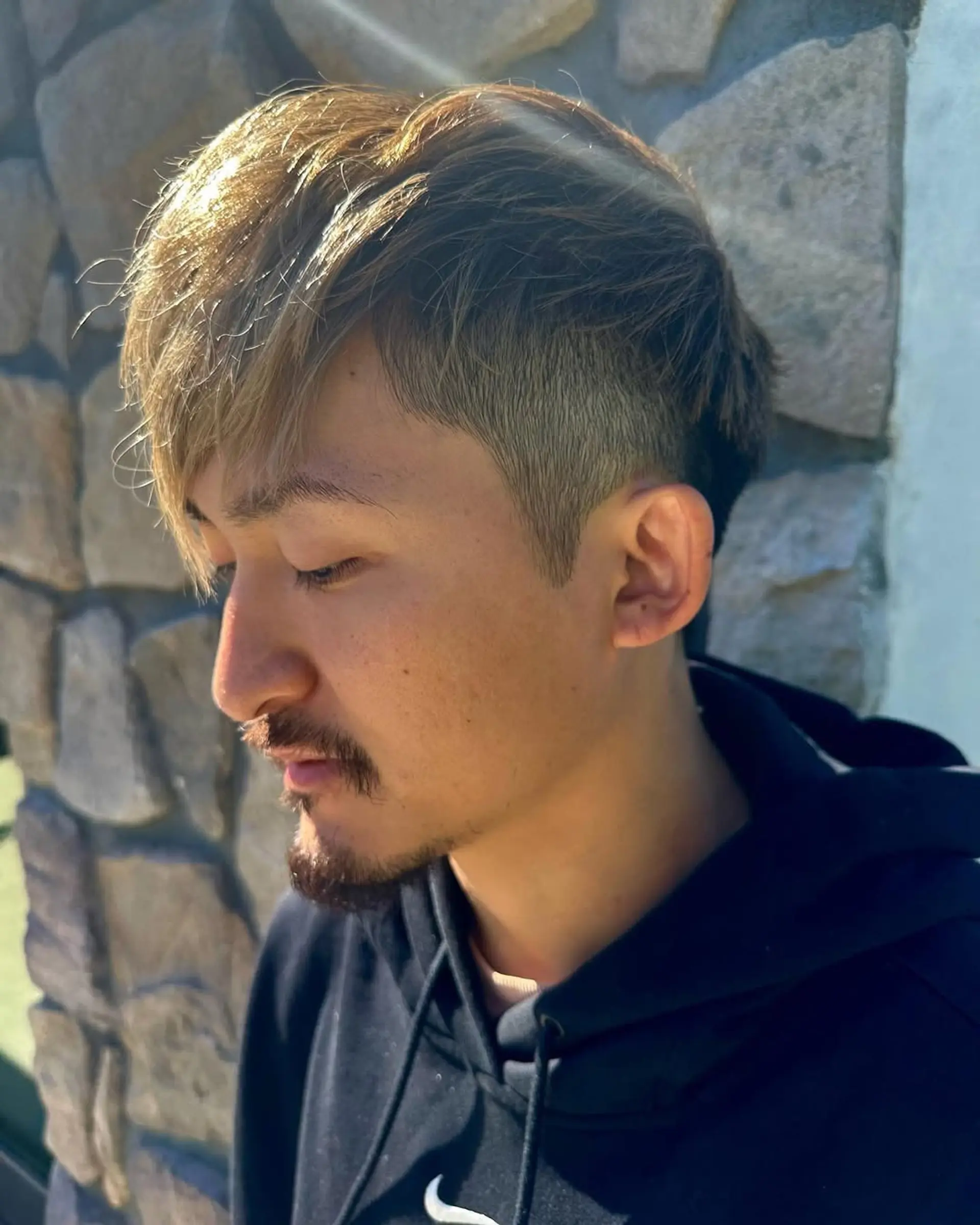 A stylish, short hairstyle with an undercut, highlighted by textured layers and an asymmetrical fringe. The blend of light brown and golden blonde highlights creates a dynamic look, perfect for a modern and fresh appearance.

Mention: Ryota One Ok Rock 1