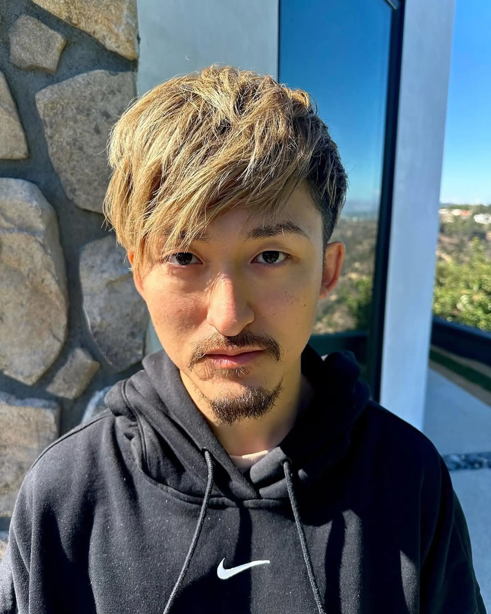 A stylish, short hairstyle with an undercut, highlighted by textured layers and an asymmetrical fringe. The blend of light brown and golden blonde highlights creates a dynamic look, perfect for a modern and fresh appearance.

Mention: Ryota One Ok Rock 2