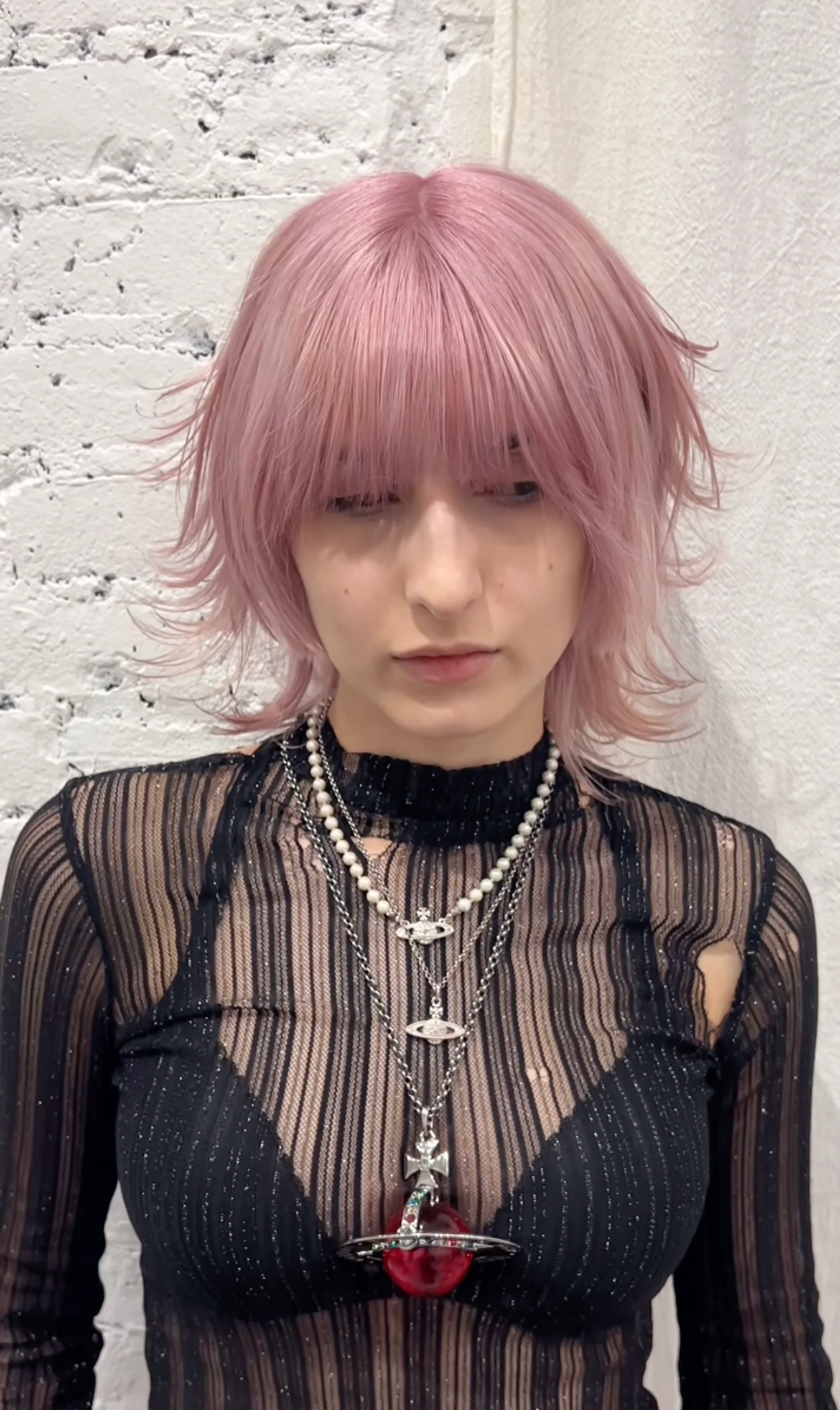 A model with a blended mullet featuring a spiky dark brown top with blonde highlights, showcasing one of NYC's top anti-trend hairstyles for 2025. - Preview 2