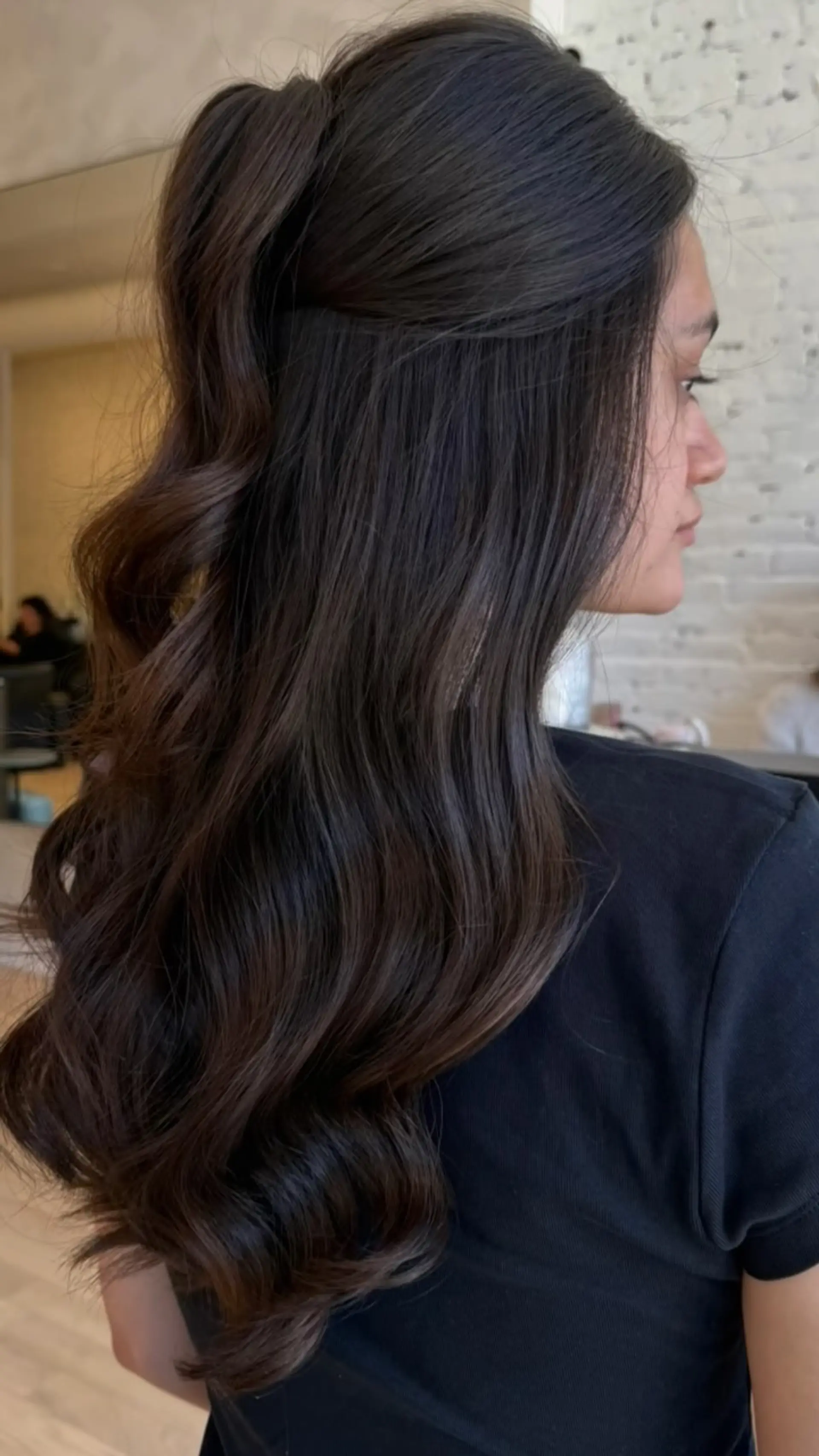 A sleek half-up high ponytail cascading into voluminous, smooth waves through deep brown hair. 1