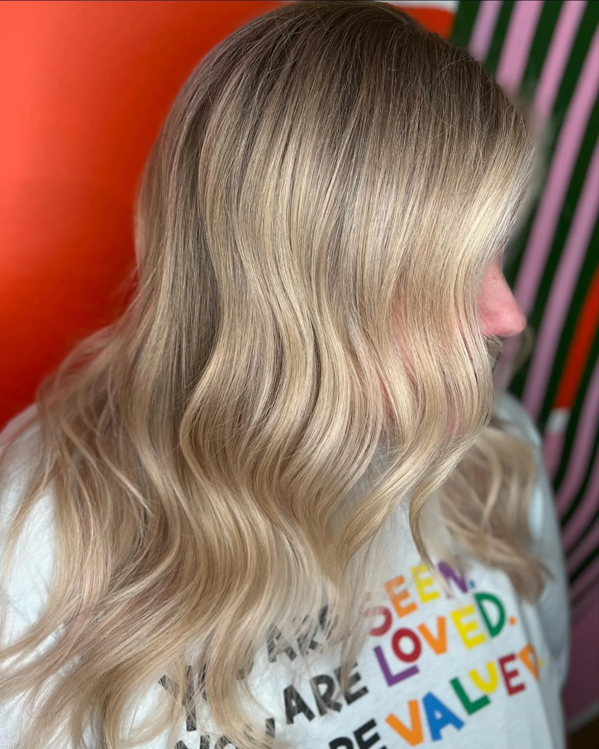 Long hair styled with soft, cascading waves showcasing a luminous blend of cool and neutral blonde highlights. 1
