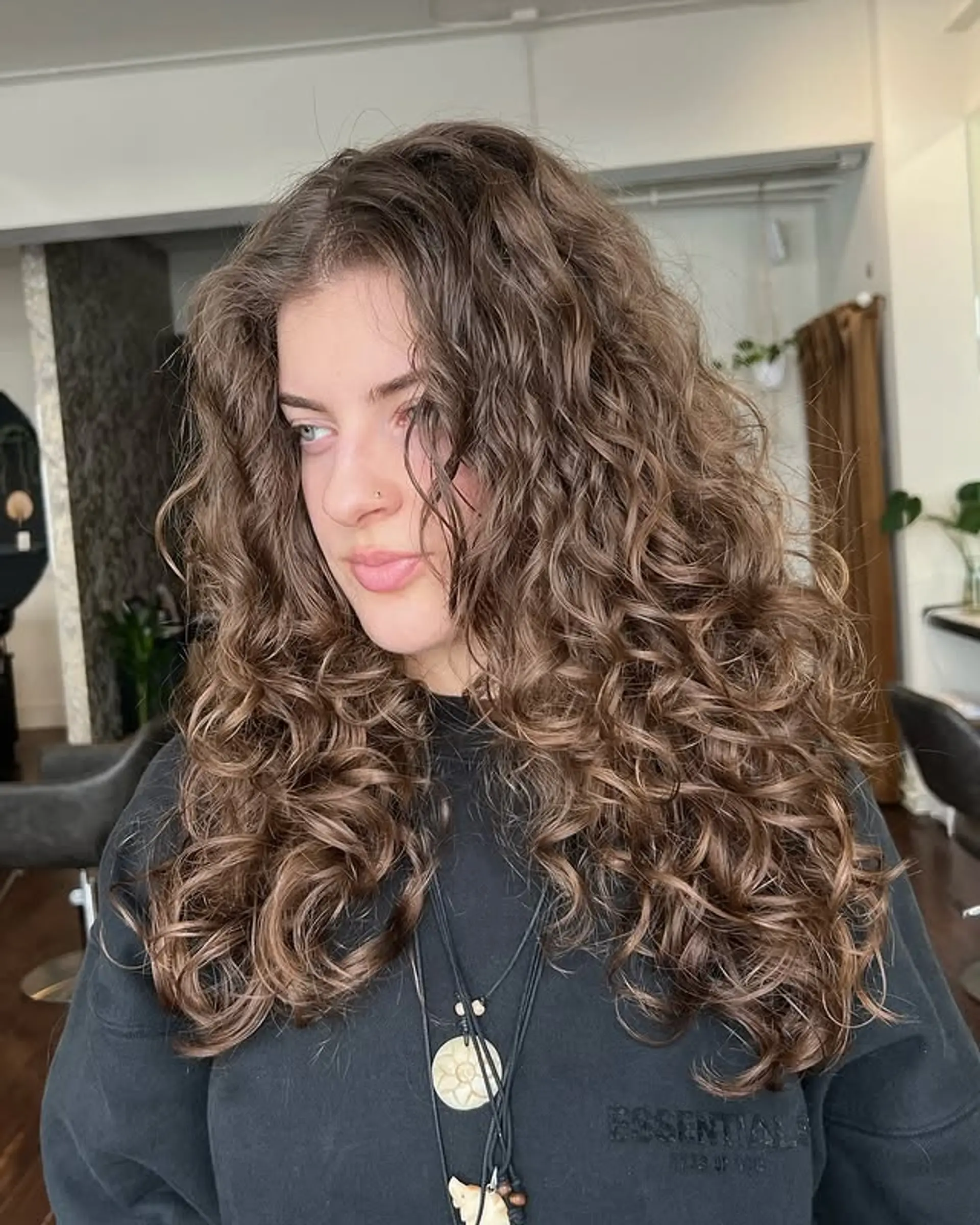 Long layered curly hair with natural defined curls. 1