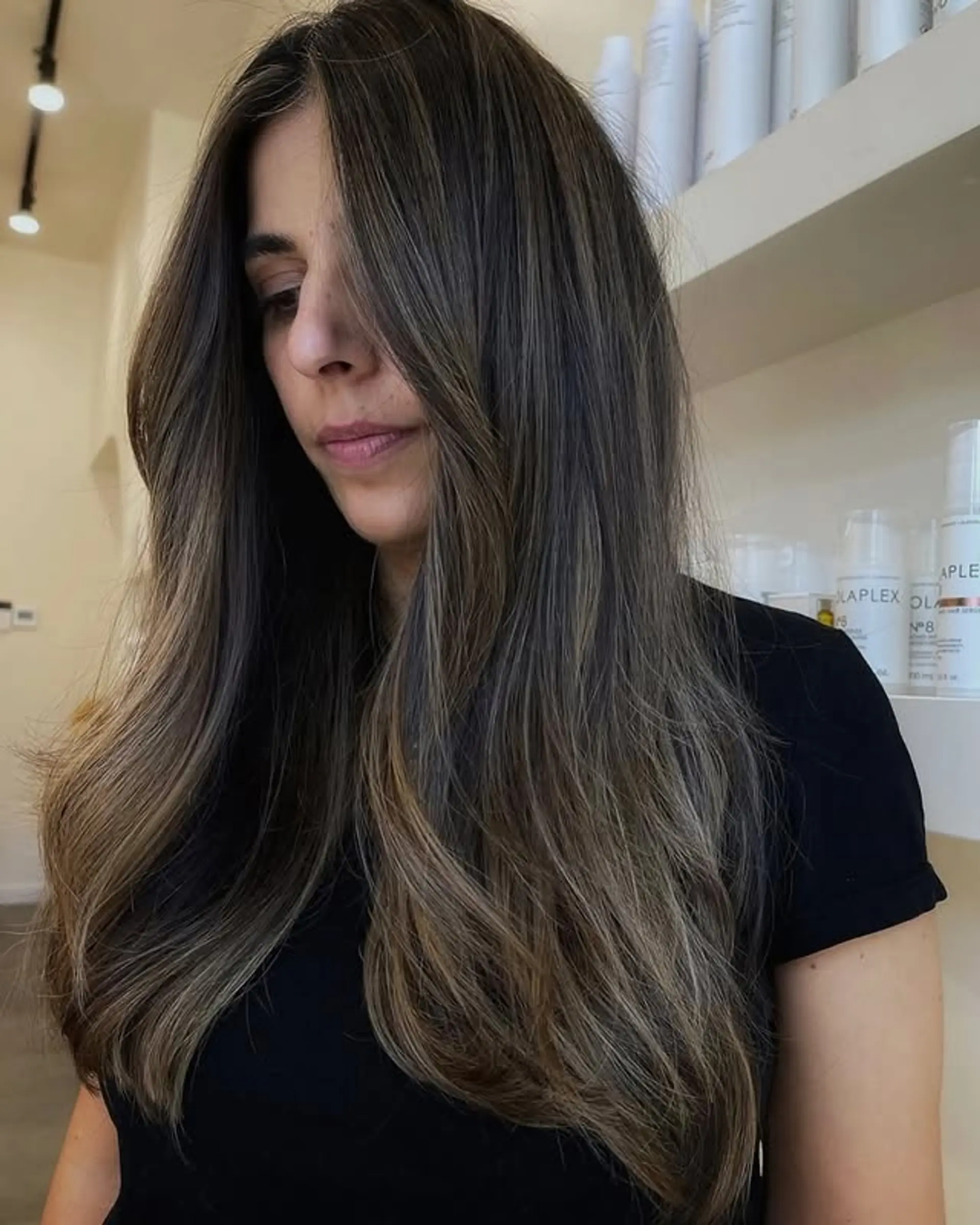 Long, layered waves with a brunette base and subtle ash blonde balayage highlights. 1