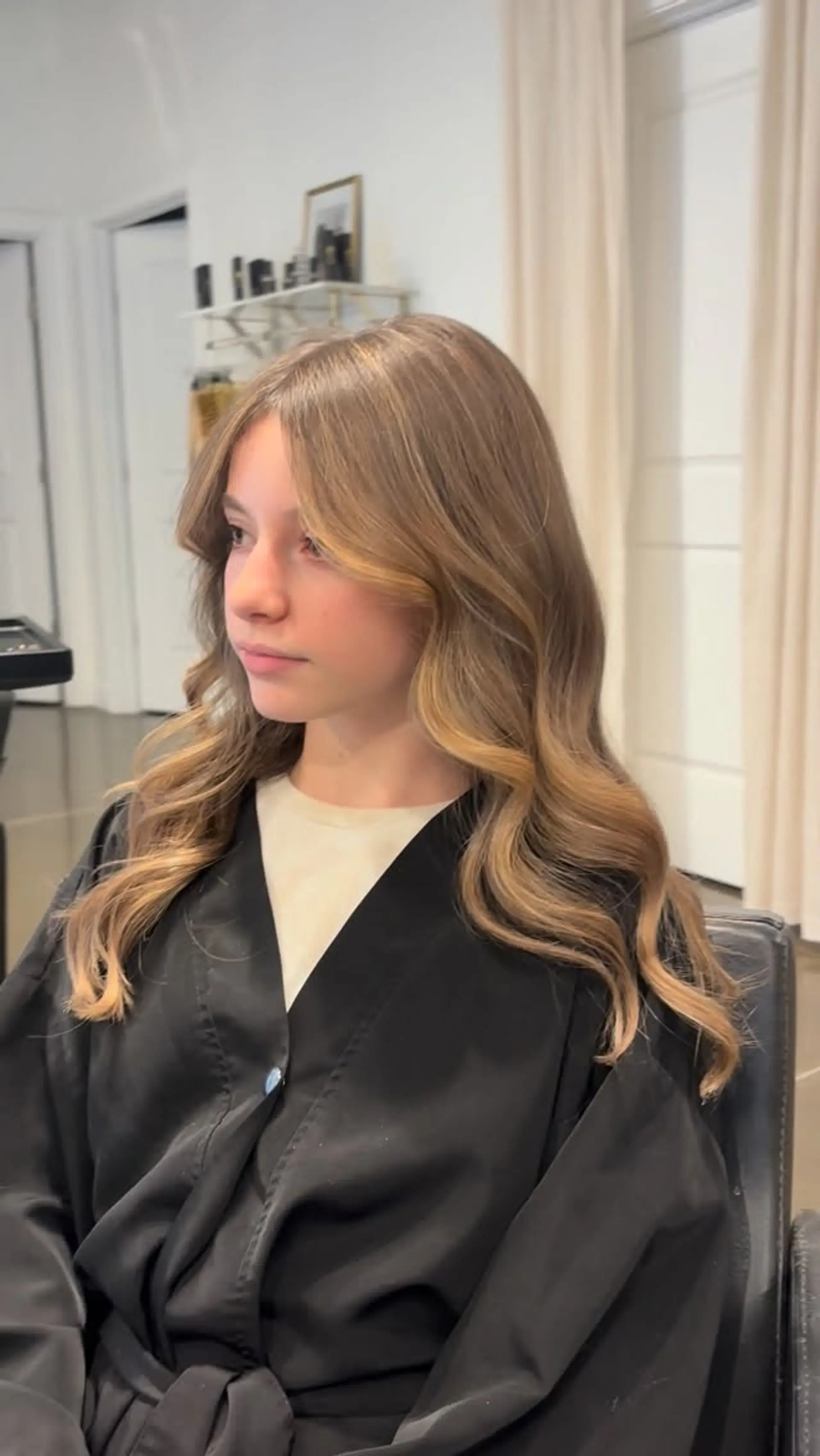 Long wavy light golden brown hair with soft honey blonde face-framing highlights and curtain bangs. 1