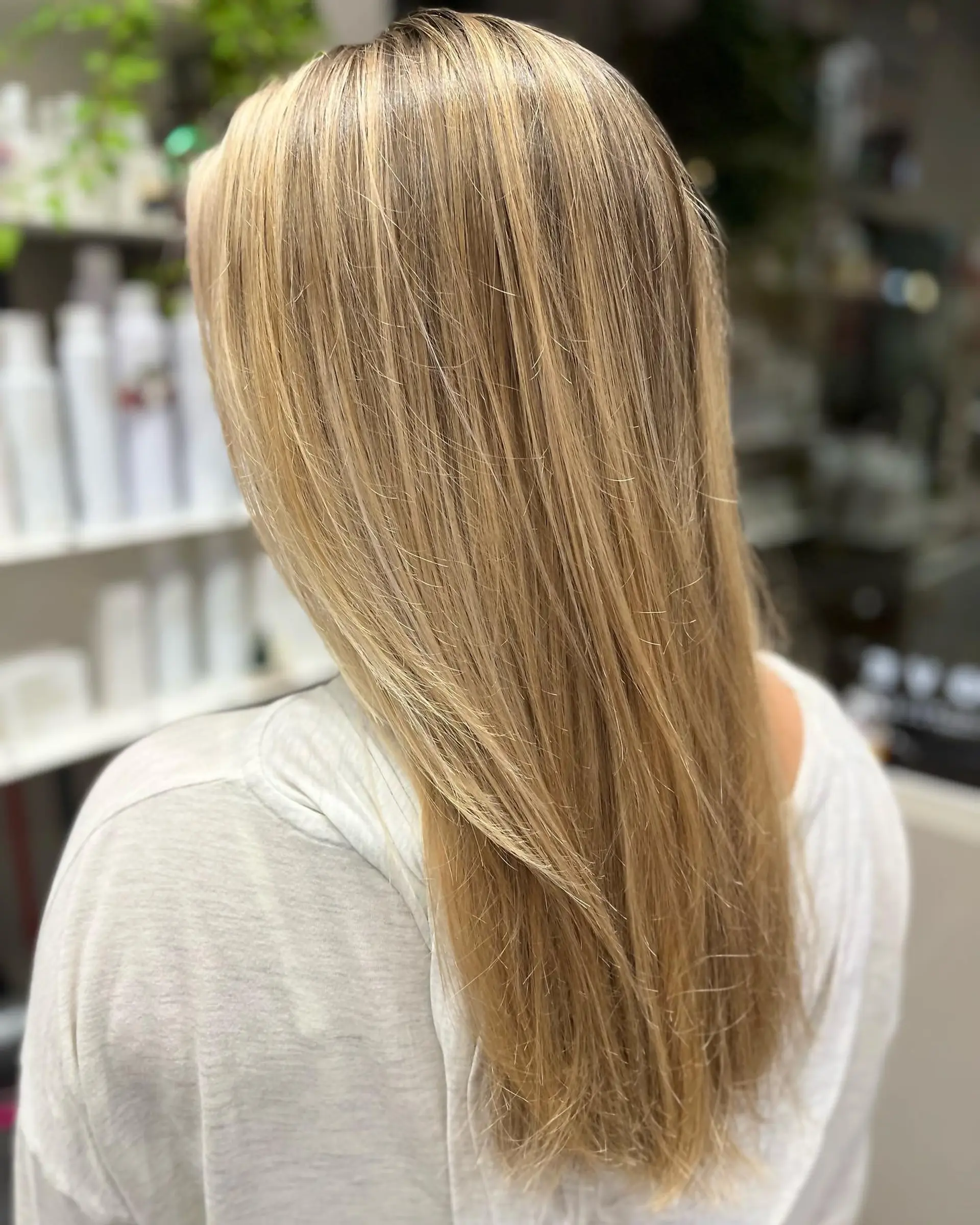 Long, straight hairstyle with a buttery blonde balayage and face framing layers. 1