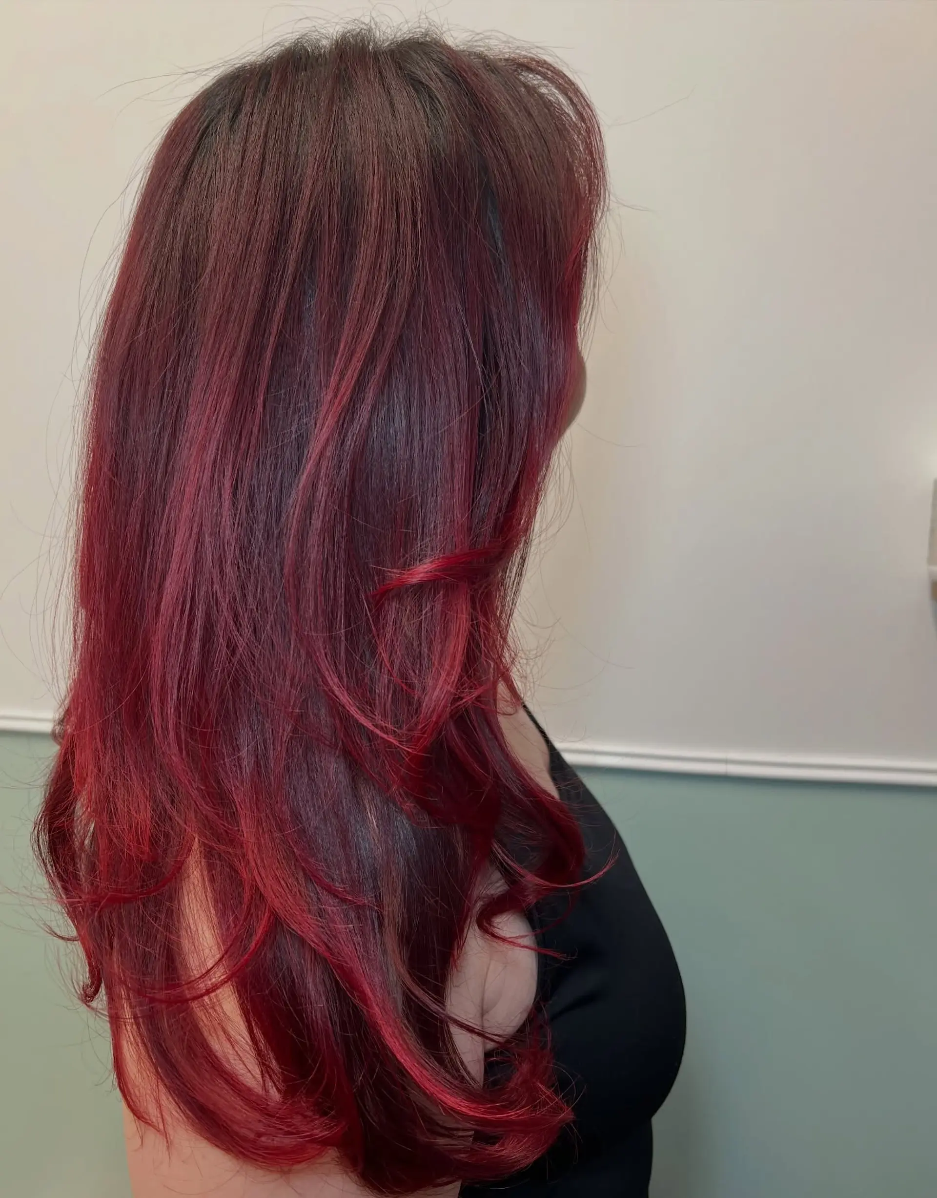 Long vibrant red hair cut in flowing layers with soft, textured flips at the ends. 1